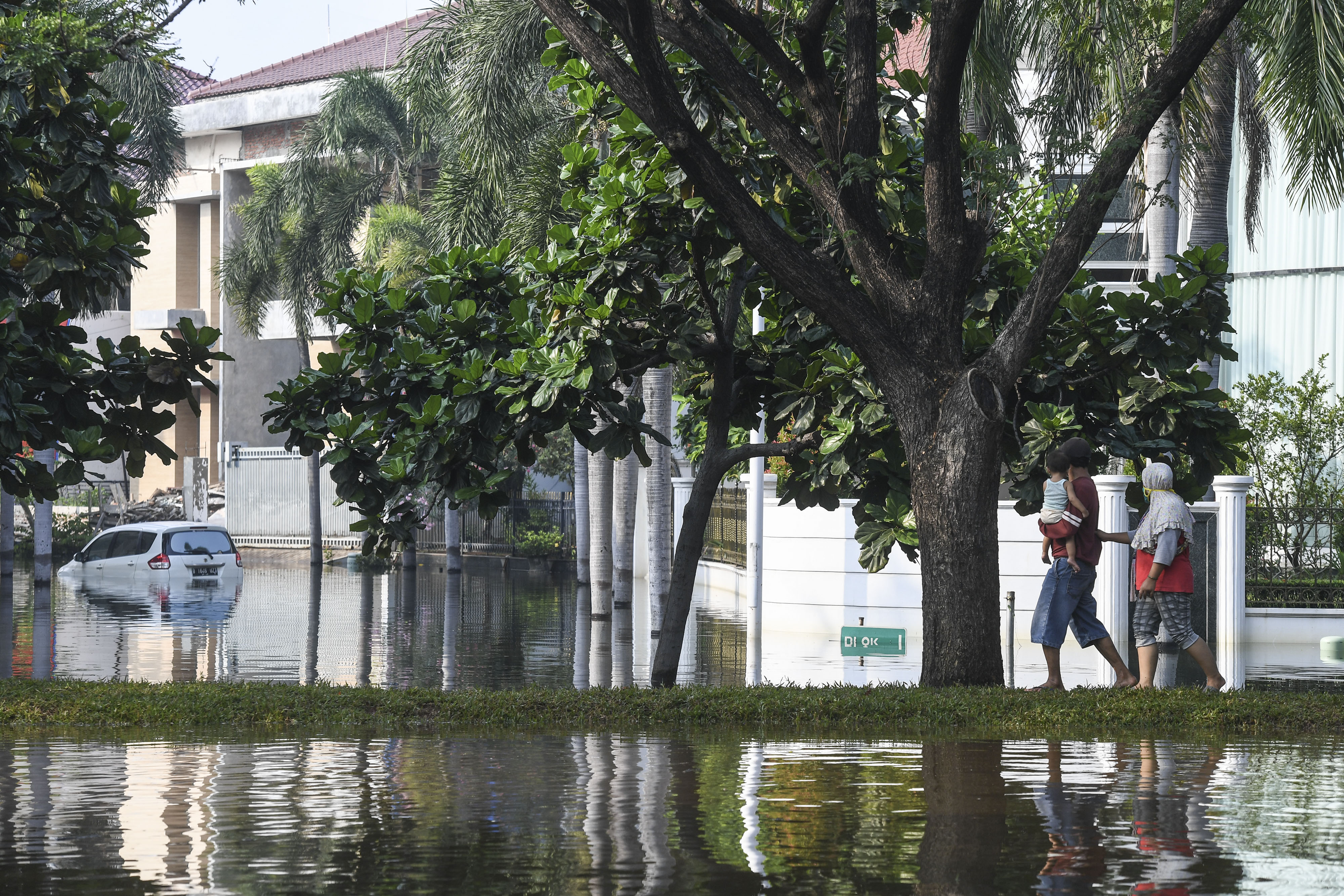  Warga melintas di Kompleks Pantai Mutiara yang tergenang banjir di Penjaringan, Jakarta (& Juni 2020)