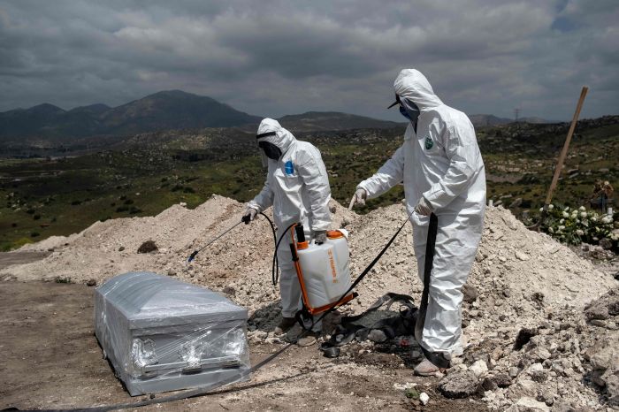 Petugas pemakaman bersiap memakamkan jenazah pasien covid-19 di Tijuana, Meksiko.  