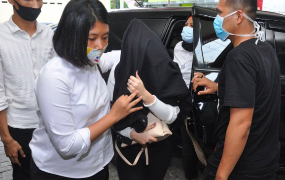 Personel kepolisian membawa artis berinisial H (tengah) saat menjalani pemeriksaan kesehatan di Rumah Sakit Bhayangkara Polda Sumut, Medan.