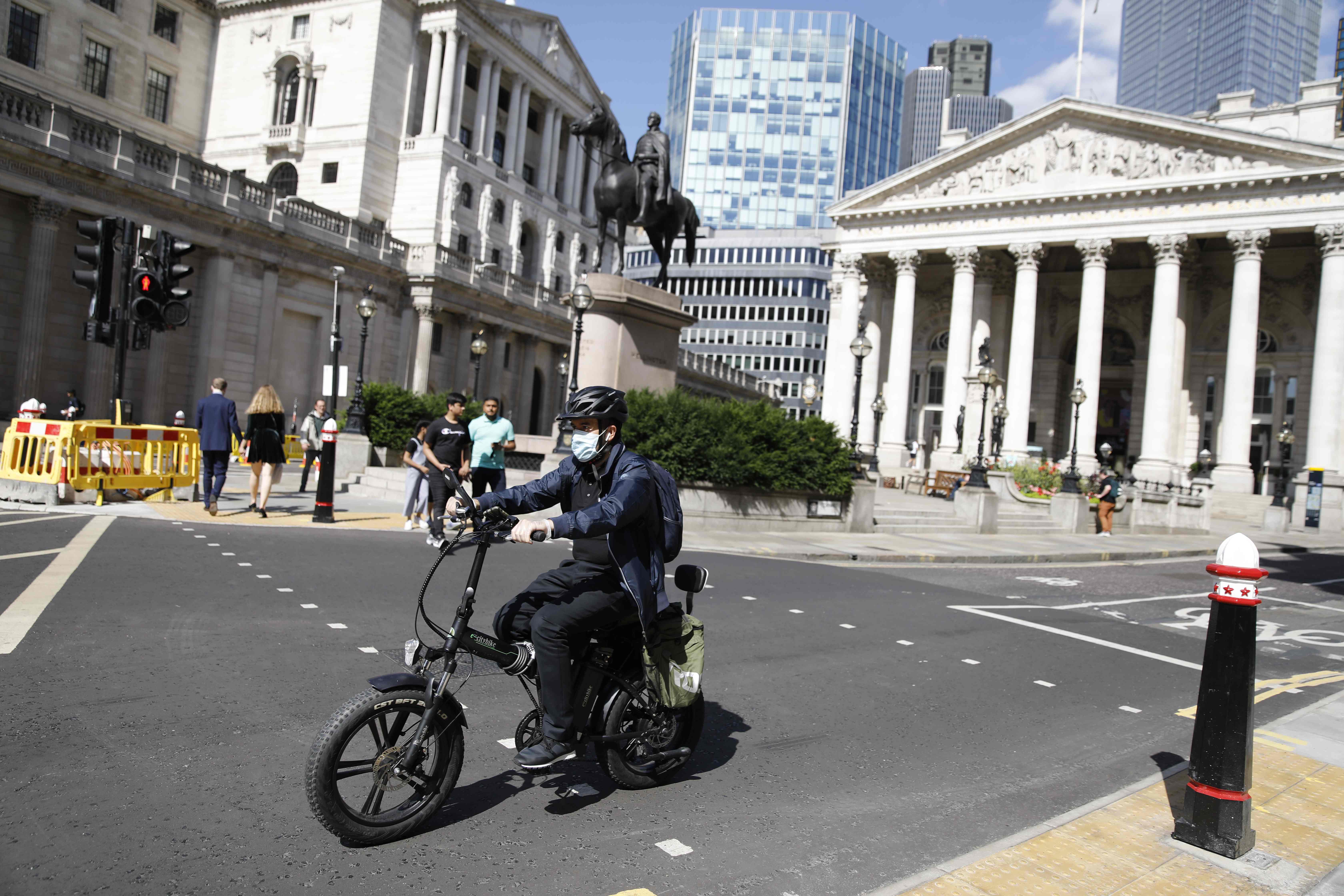 Seorang warga bersepeda di jalanan Kota London, Inggris.