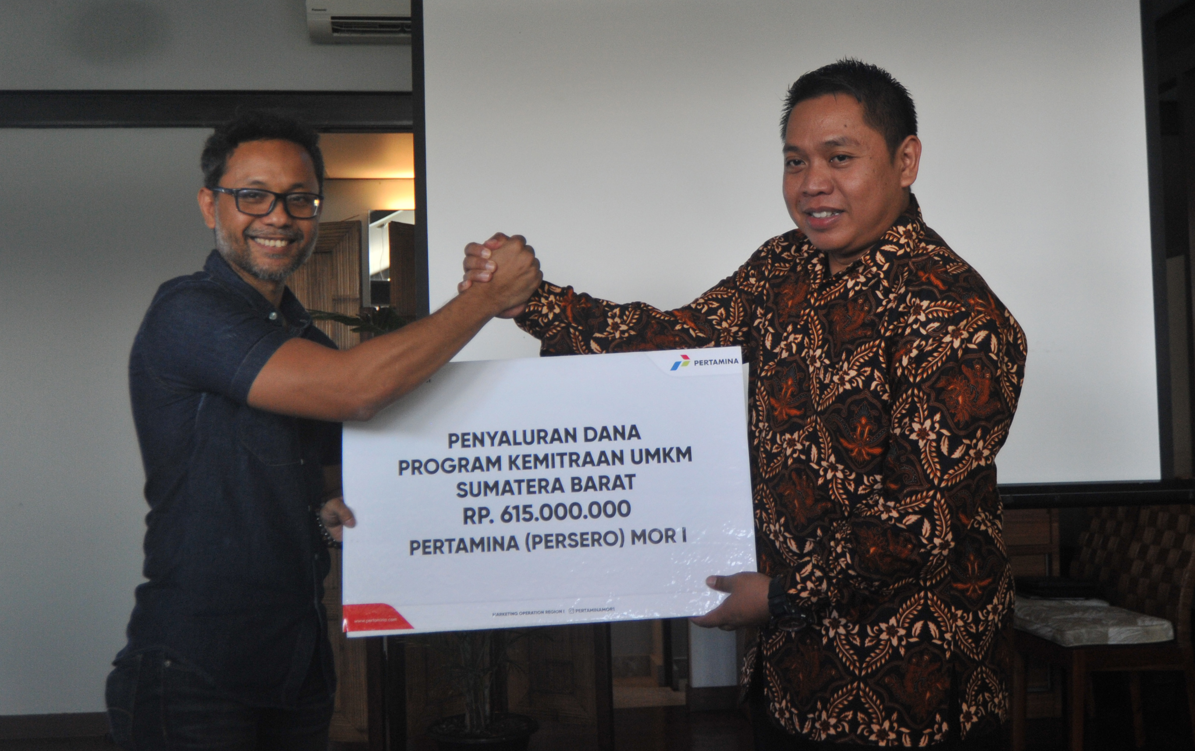 Unit Manager Communication and CSR Pertamina MORI, Roby Hervindo (kiri), menyerahkan secara simbolis dana program kemitraan UMKM