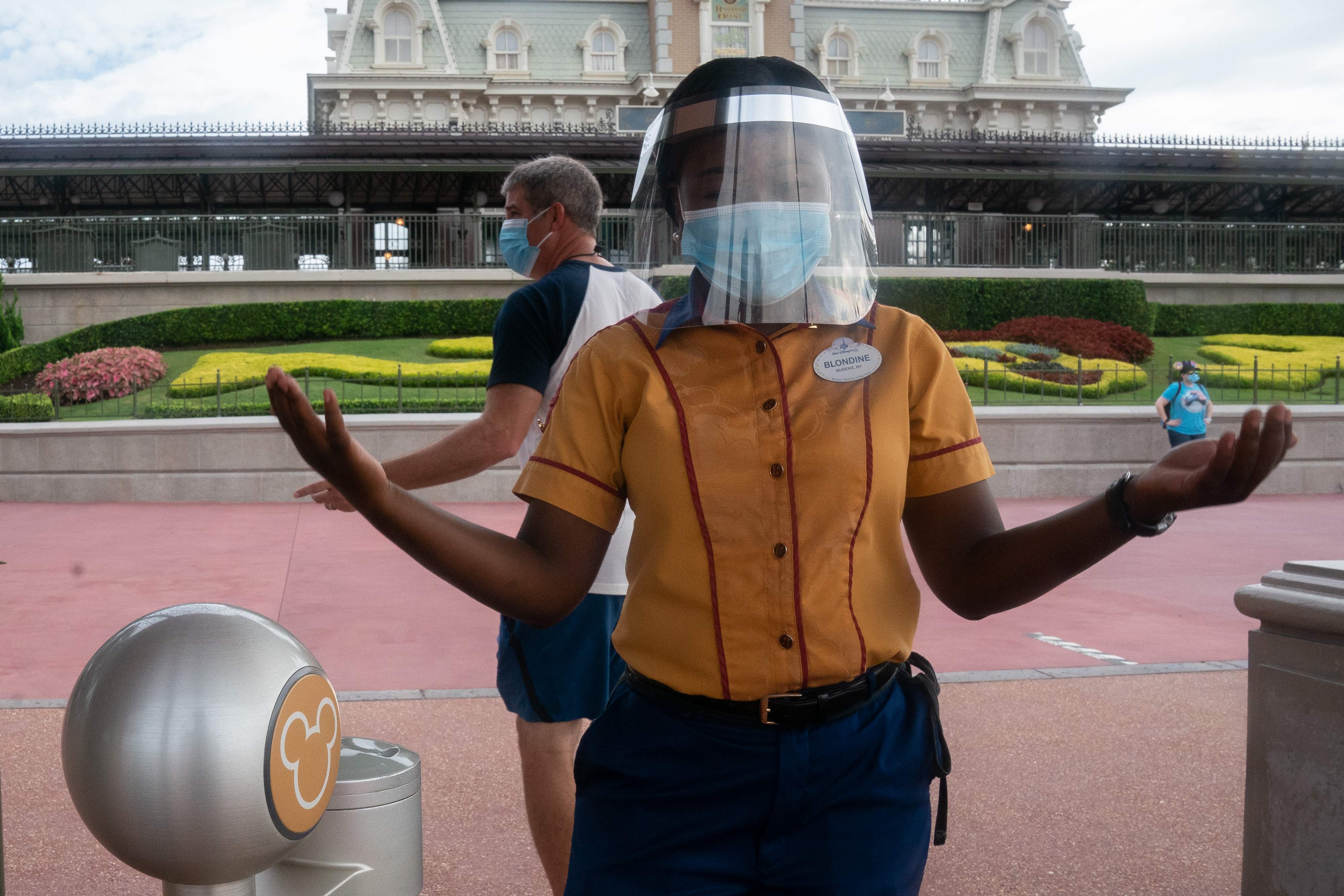 Petugas di Walt Disney World Resort mengenakan masker dan face shield di pintu masuk taman bermain itu di Orlando, Florida.