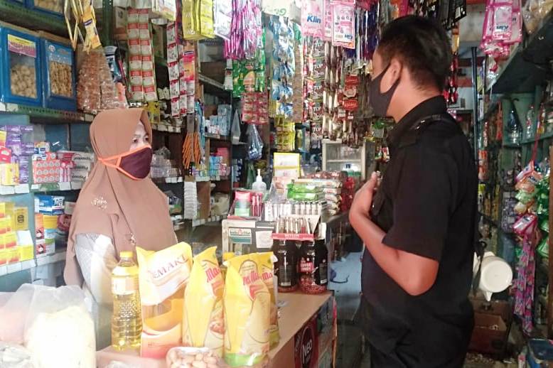 Petugas retribusi UPT Pasar Ngadirejo menarik retribusi sambil mengingatkan pedagang agar memakai masker dan menerapkan protokol kesehatan.