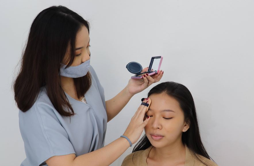 Penata rias sedang mempraktekan cara merias wajah ala k-beauty.
