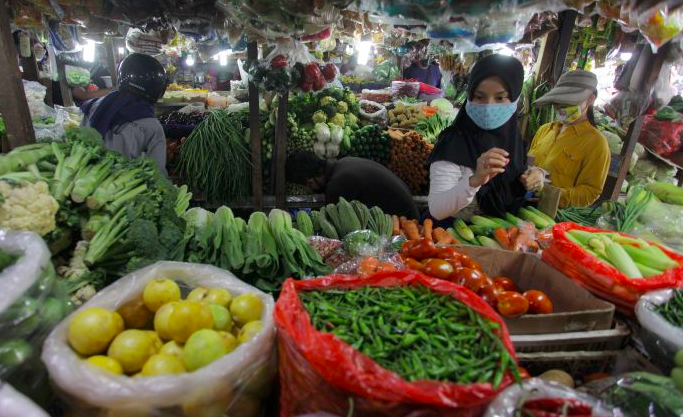 Warga bermasker sedang memilih sayuran di pasar tradisional Pondok Labu, Jakarta (7/6/2020).