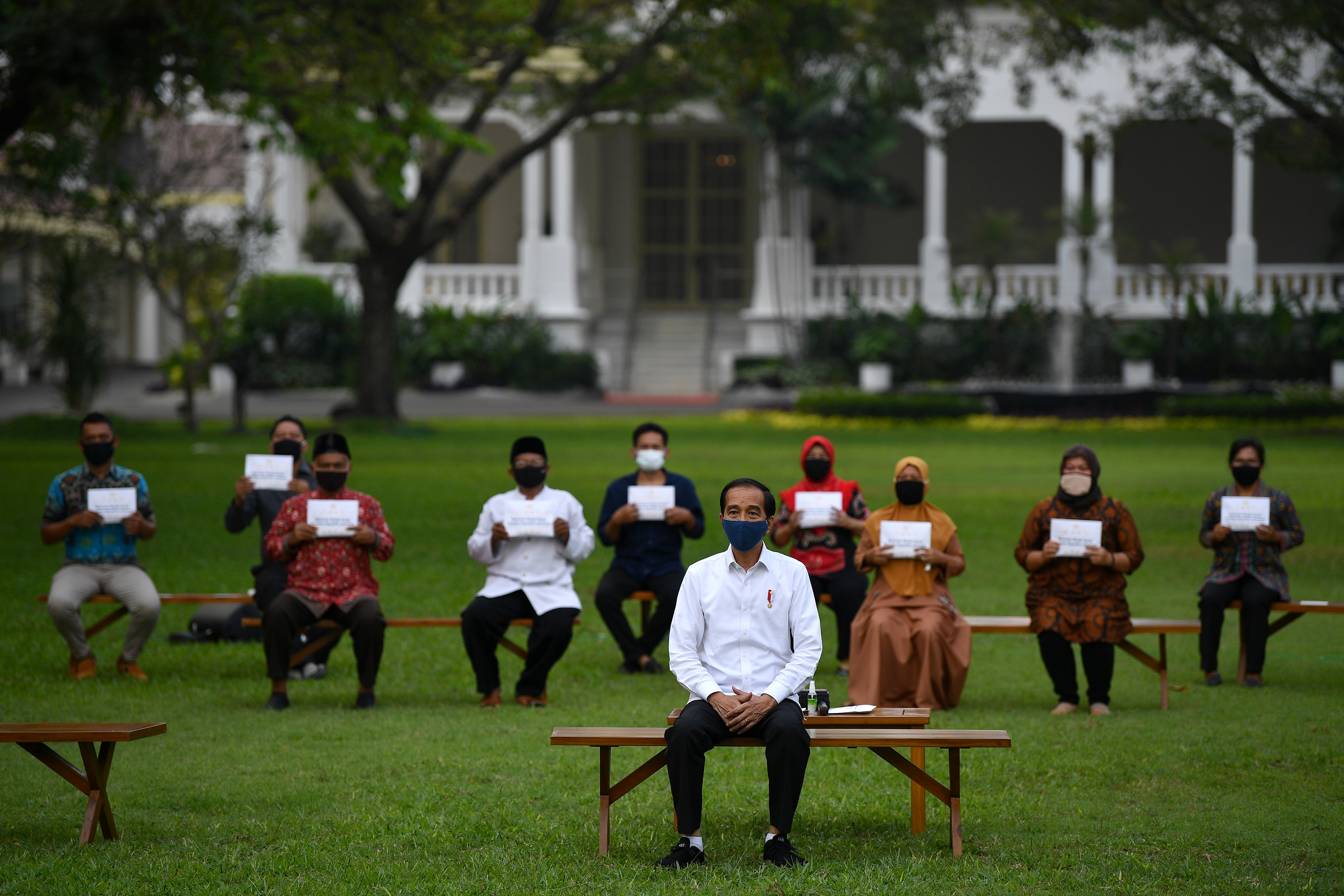 Presiden Joko Widodo berfoto bersama penerima bantuan modal kerja di halaman tengah Istana Merdeka, Jakarta, hari ini.