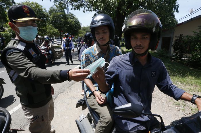 Tim gabungan penertiban peraturan daerah dari Satpol PP, TNI dan Polri meminta warga menggunakan masker di Banda Aceh.