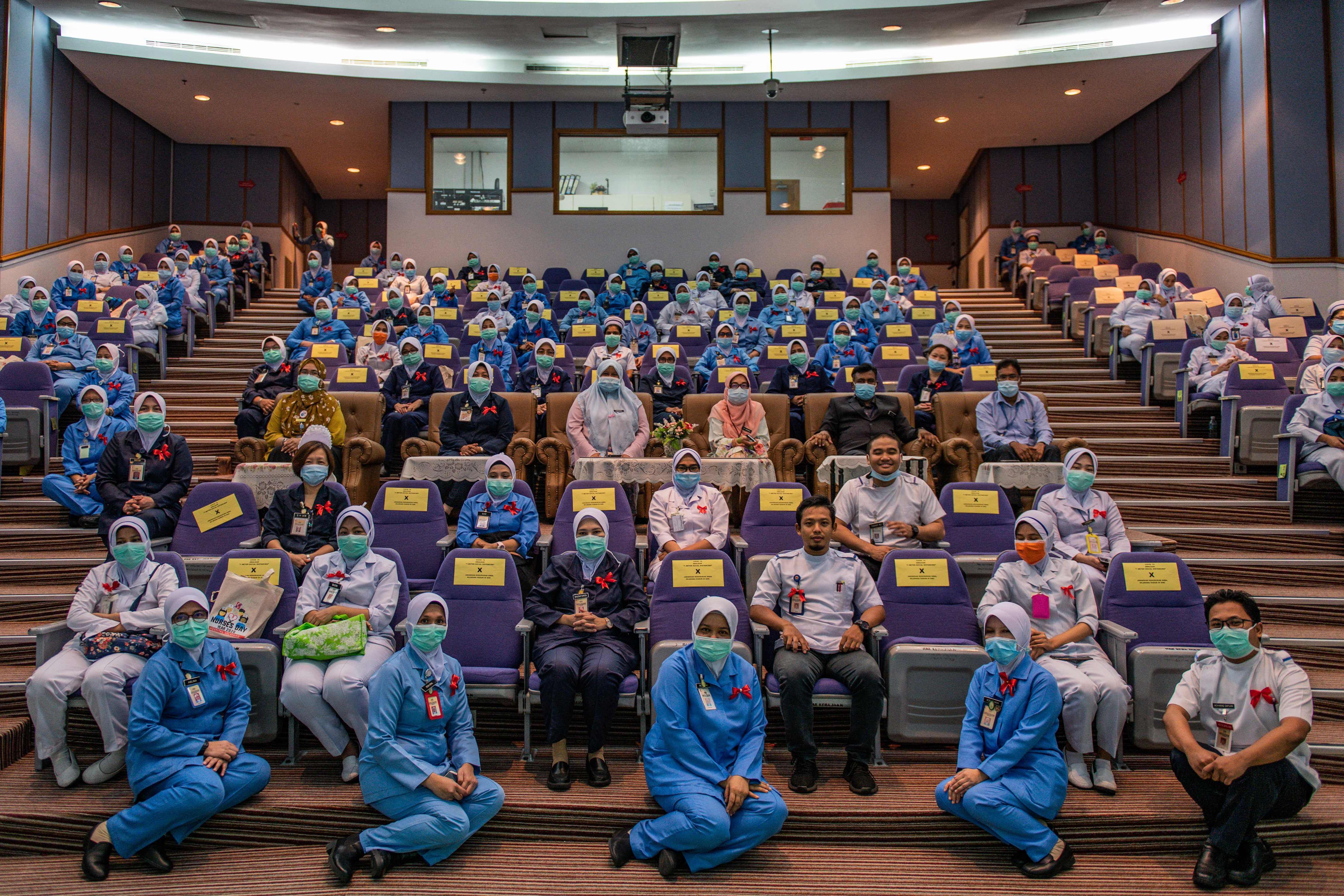 Para perawat Malaysia mengenakan masker untuk mencegah penularan virus korona saat merayakan Hari Perawat Internasional di Selayang.