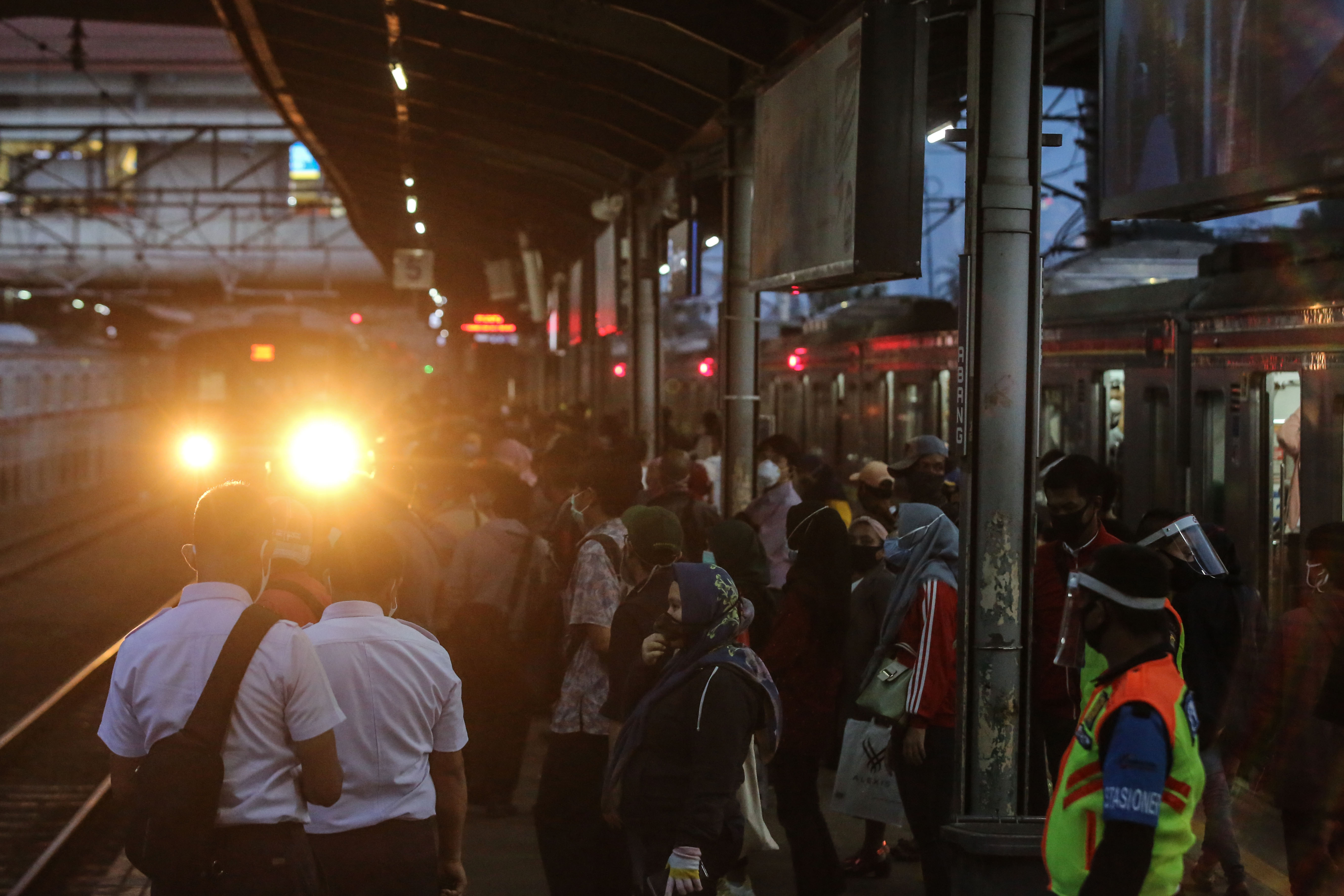 Penumpang menunggu kedatangan KRL commuter line.