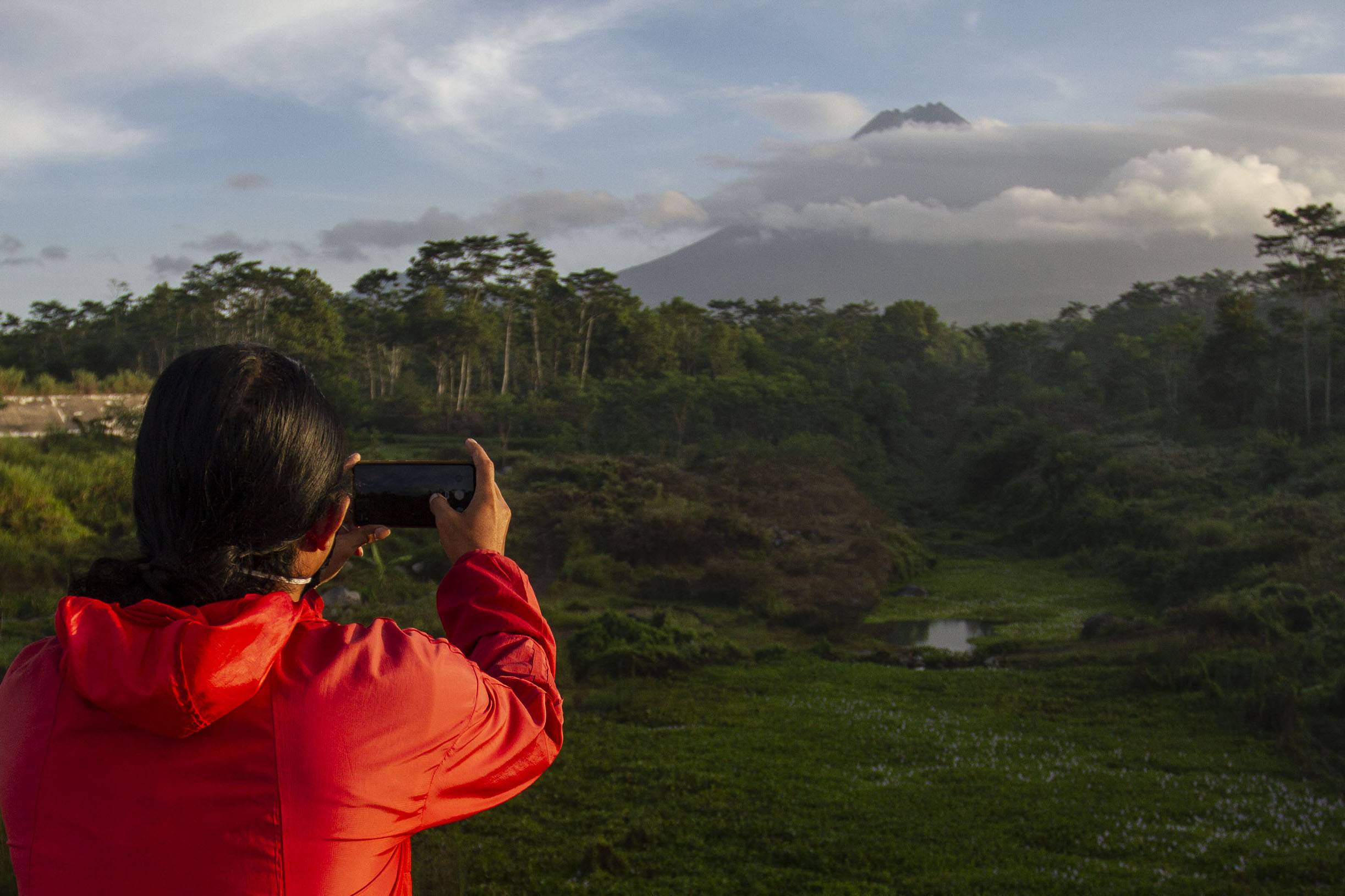 Puncak Gunung Merapi yang diselimuti awan terlihat dari Bronggang, Cangkringan, Sleman, DI Yogyakarta, Kamis (9/7/2020)