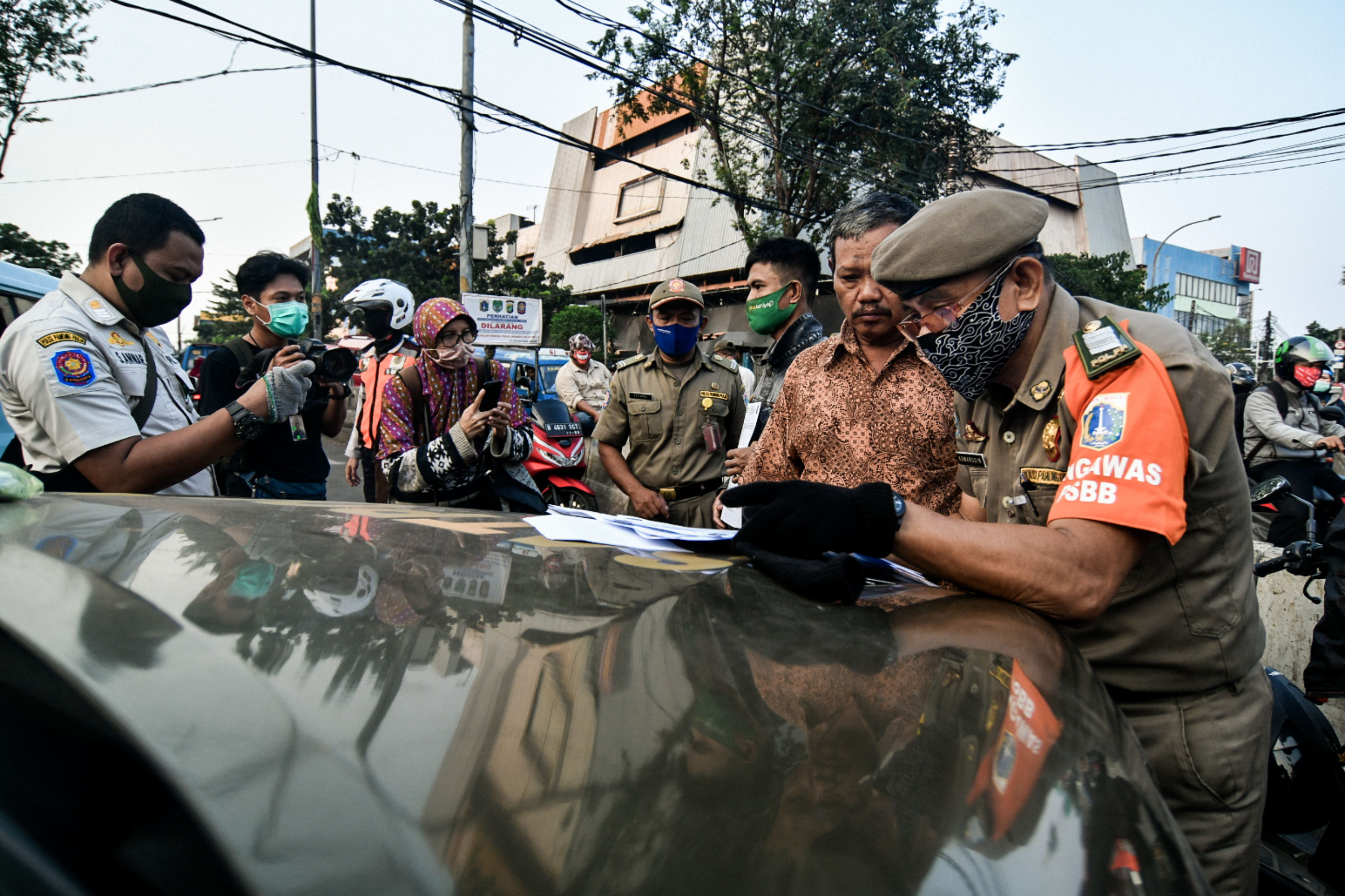 Petugas menindak pengendara yang tidak menggunakan masker di kawasan Pasar Minggu, Jakarta.