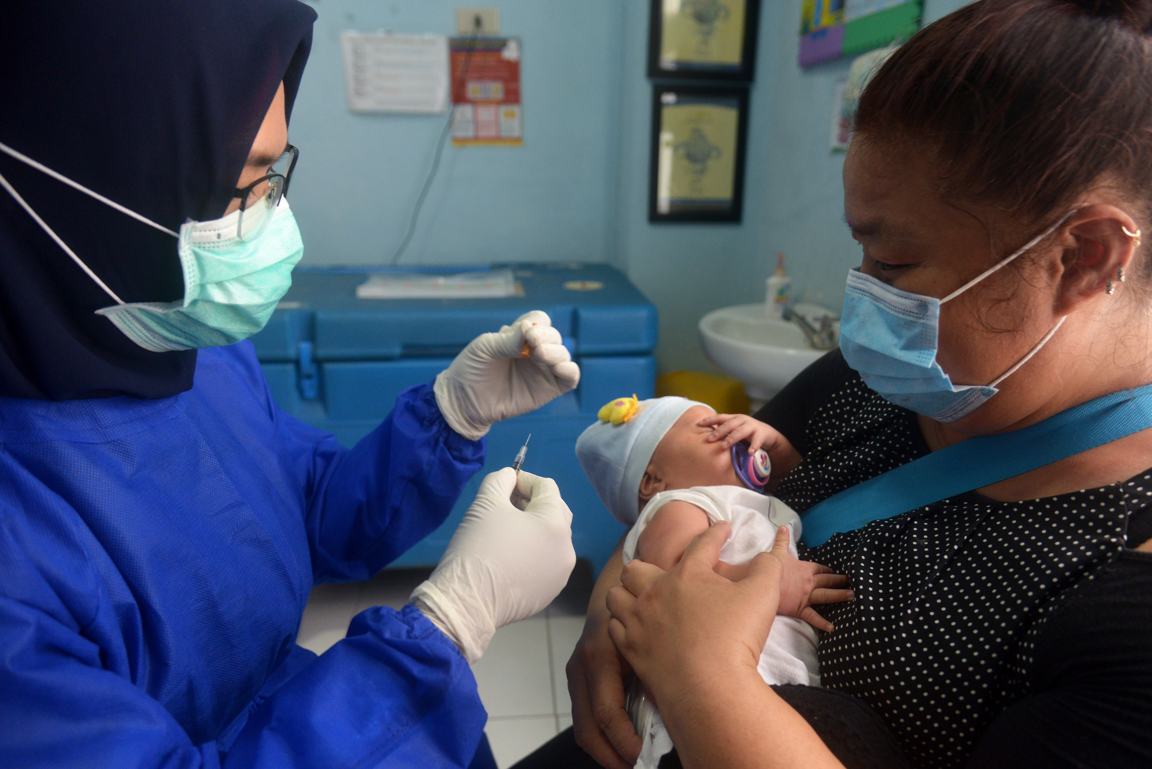 Petugas kesehatan bersiap menyuntikan vaksin BCG dan polio kepada bayi di Pukesmas Kuta Alam, Banda Aceh, Aceh, Senin (15/6).