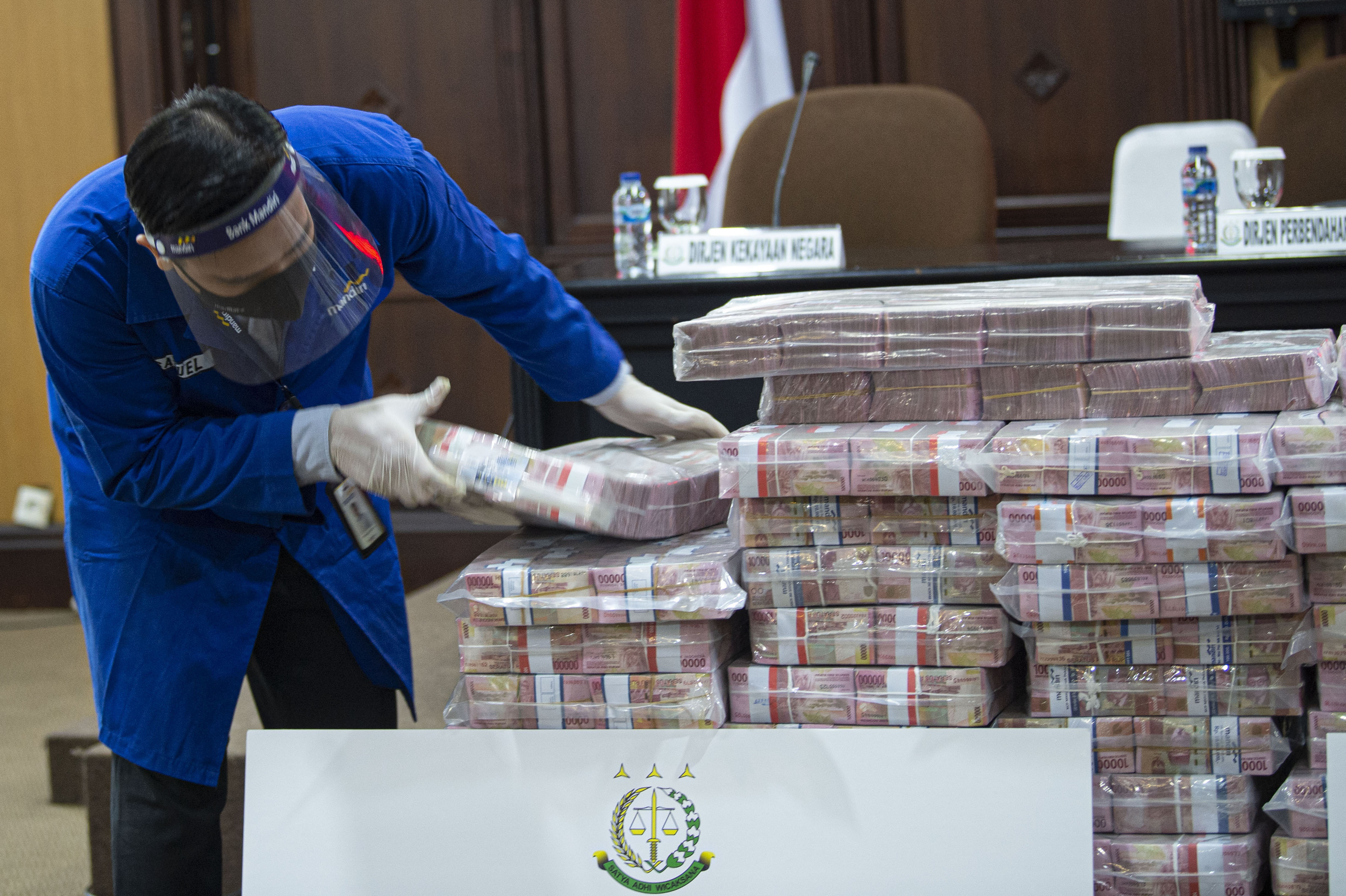 Petugas menata barang bukti berupa uang sitaan di kantor Kejaksaan Agung (Kejagung), Jakarta, Selasa (7/7/2020). 