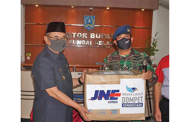 PENYALURAN BANTUAN MEDIA GROUP: Komandan Lanud Syamsudin Noor, Kolonel M Taufi q Arasj (kanan) menyerahkan bantuan APD dari Media Group  