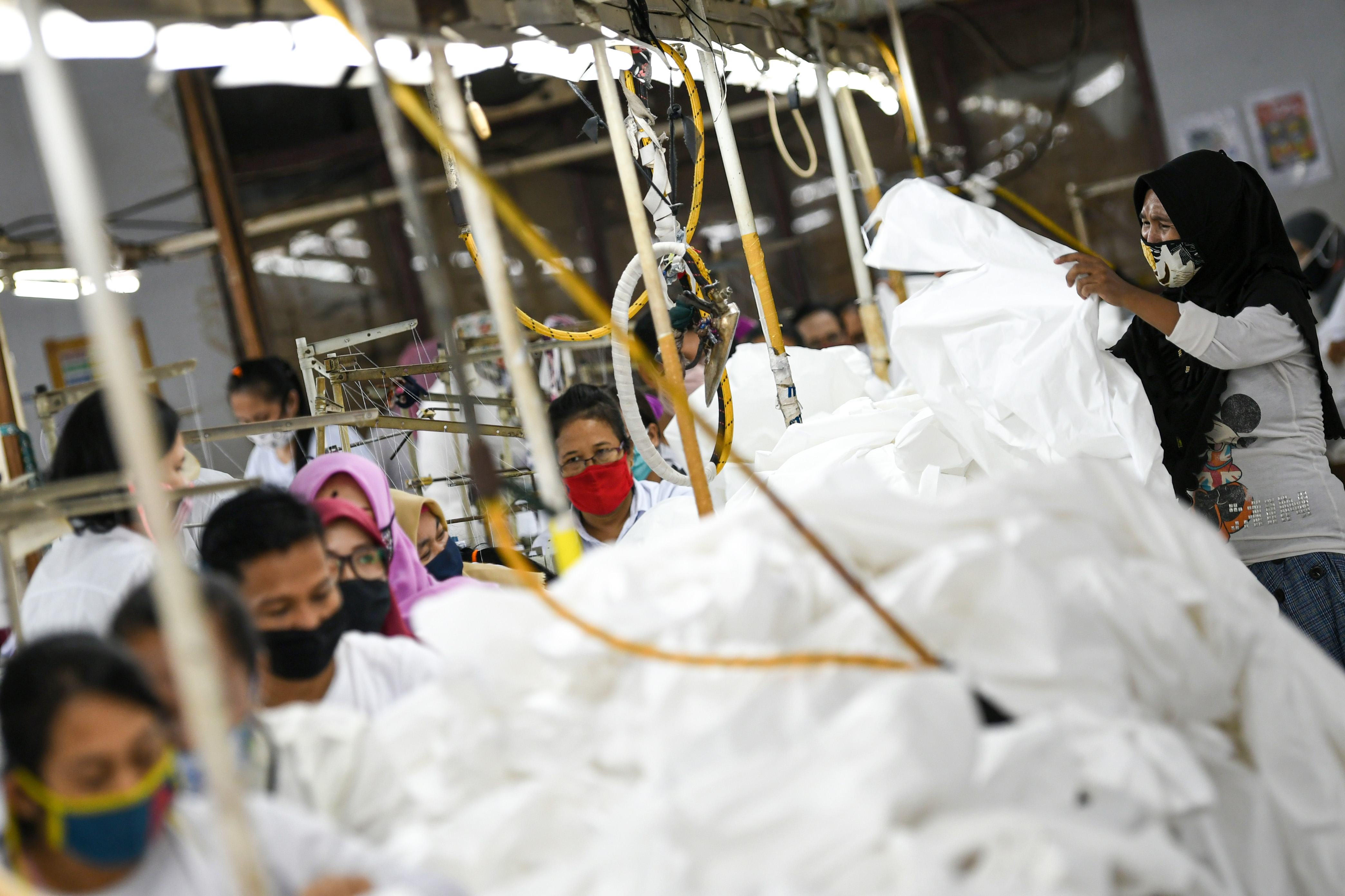 Pekerja perempuan memproduksi alat pelindung diri sebuah perusahaan garmen di Jakarta