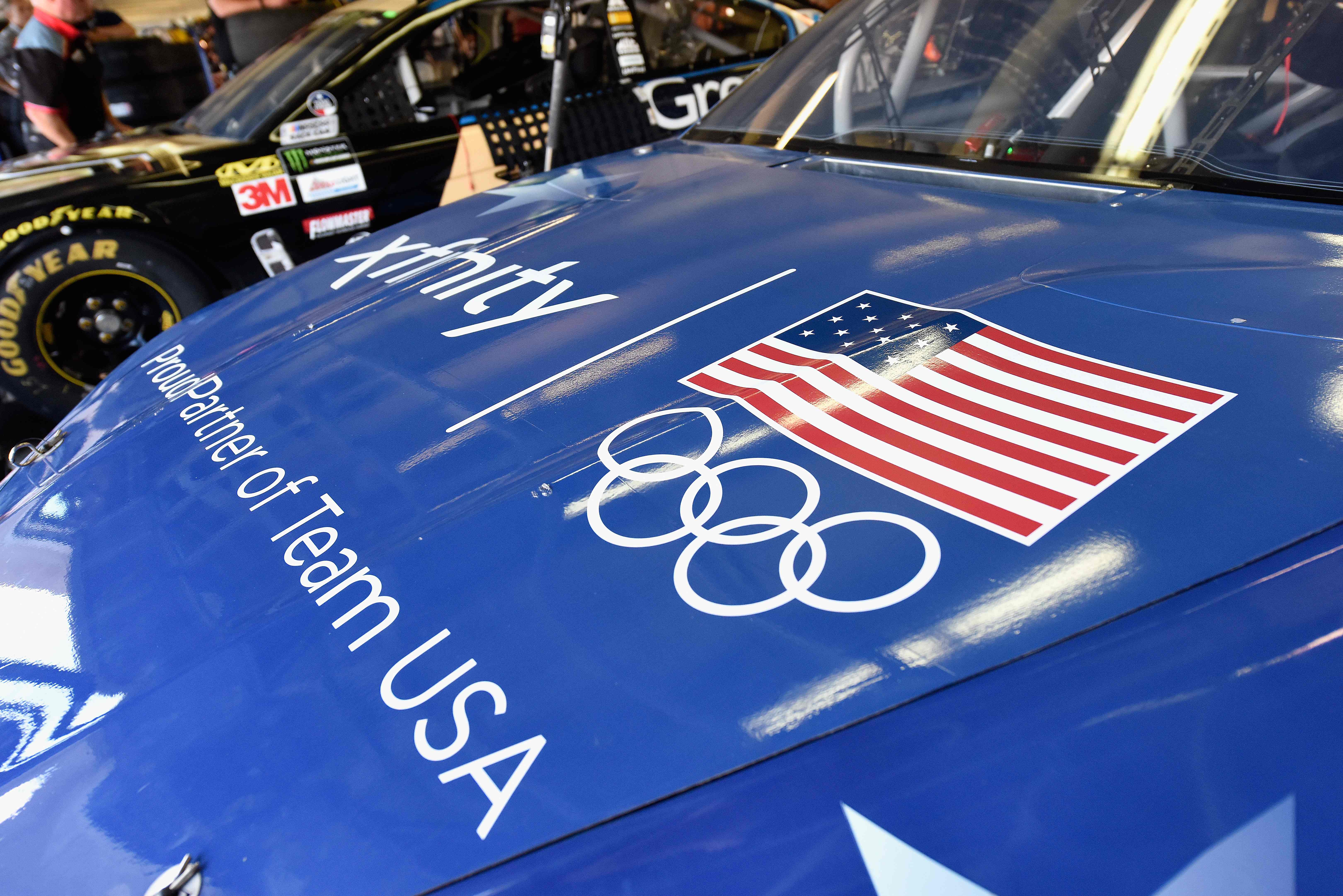 Bendera AS dan logo Olimpiade terlihat di atas sebuah mobil balap NASCAR.