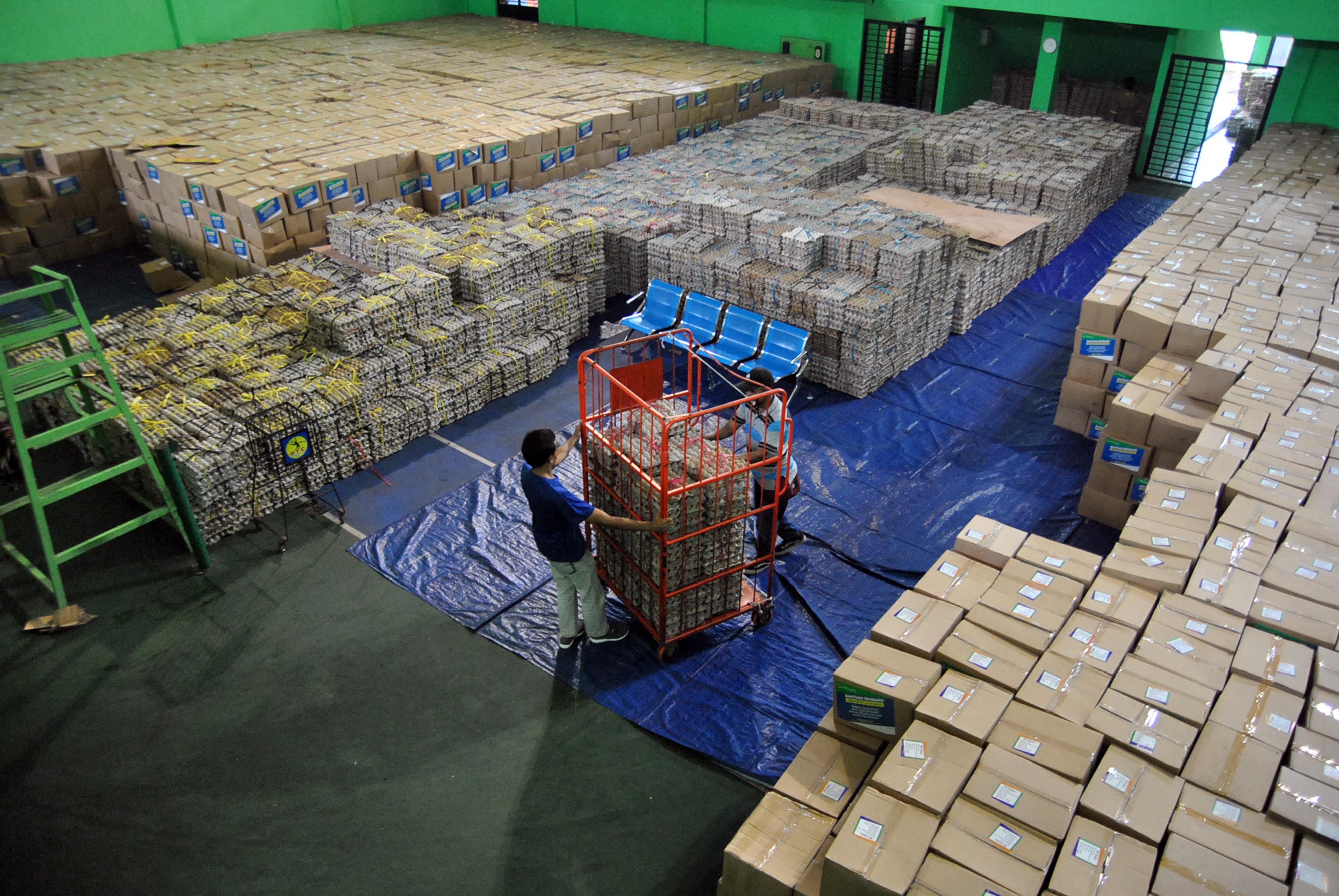 Petugas merapikan paket bansos pemerintah yang dibagikan kepada masyarakat terdampak pandemi.