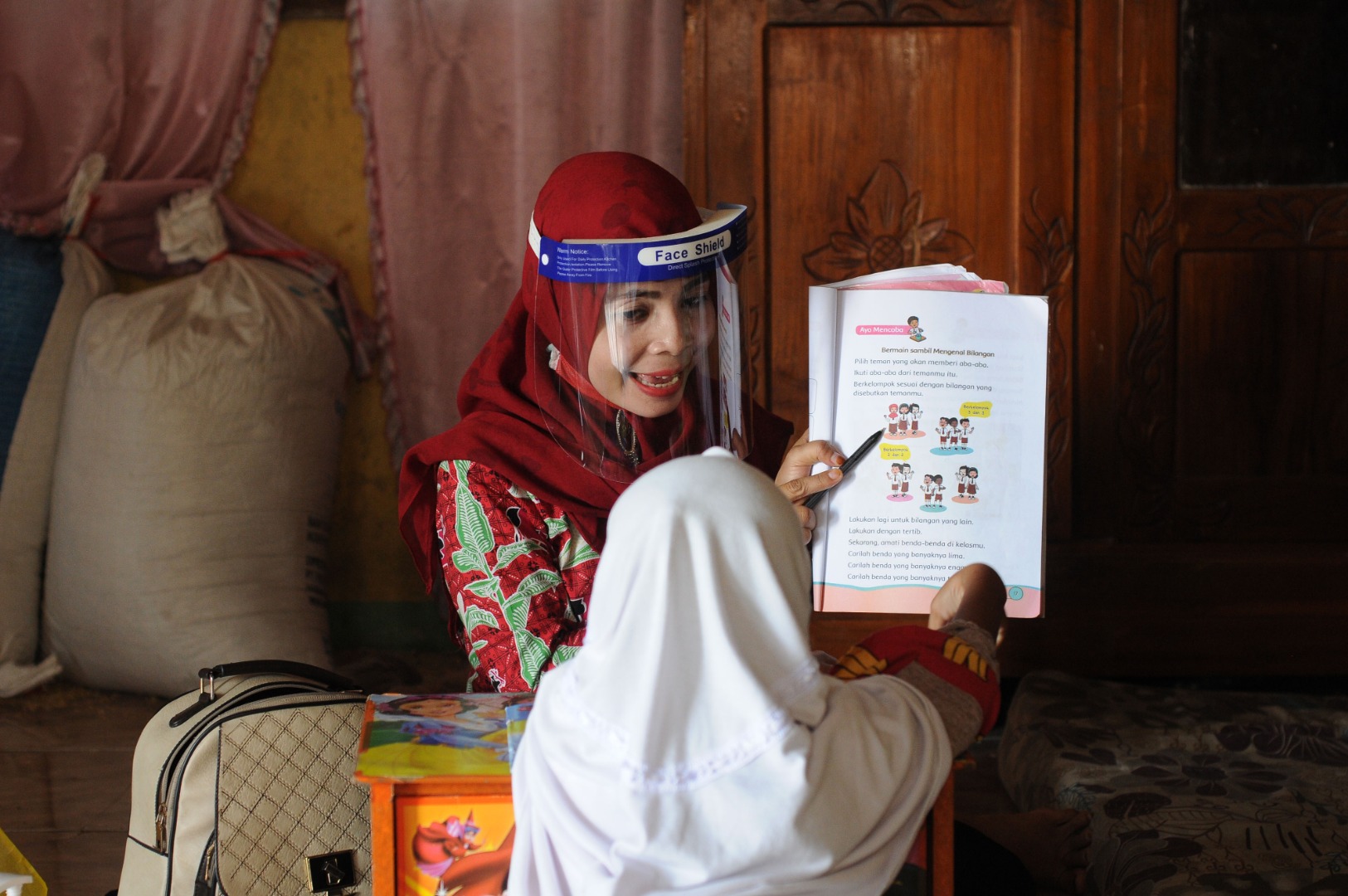 Guru SDN 2 Guli mengajar dua siswa kelas satu di rumah siswanya di Guli, Nogosari, Boyolali, Jawa Tengah, Kamis (23/7).