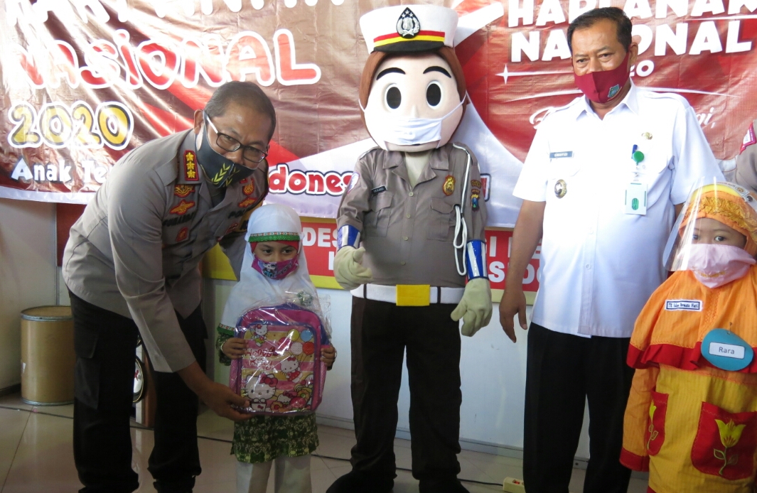 PERINGATAN HAN: Badut Polisi memberikan masker kepada anak-anak dalam rangka peringatan Hari Anak Nasional di Sidoarjo, Jatim
