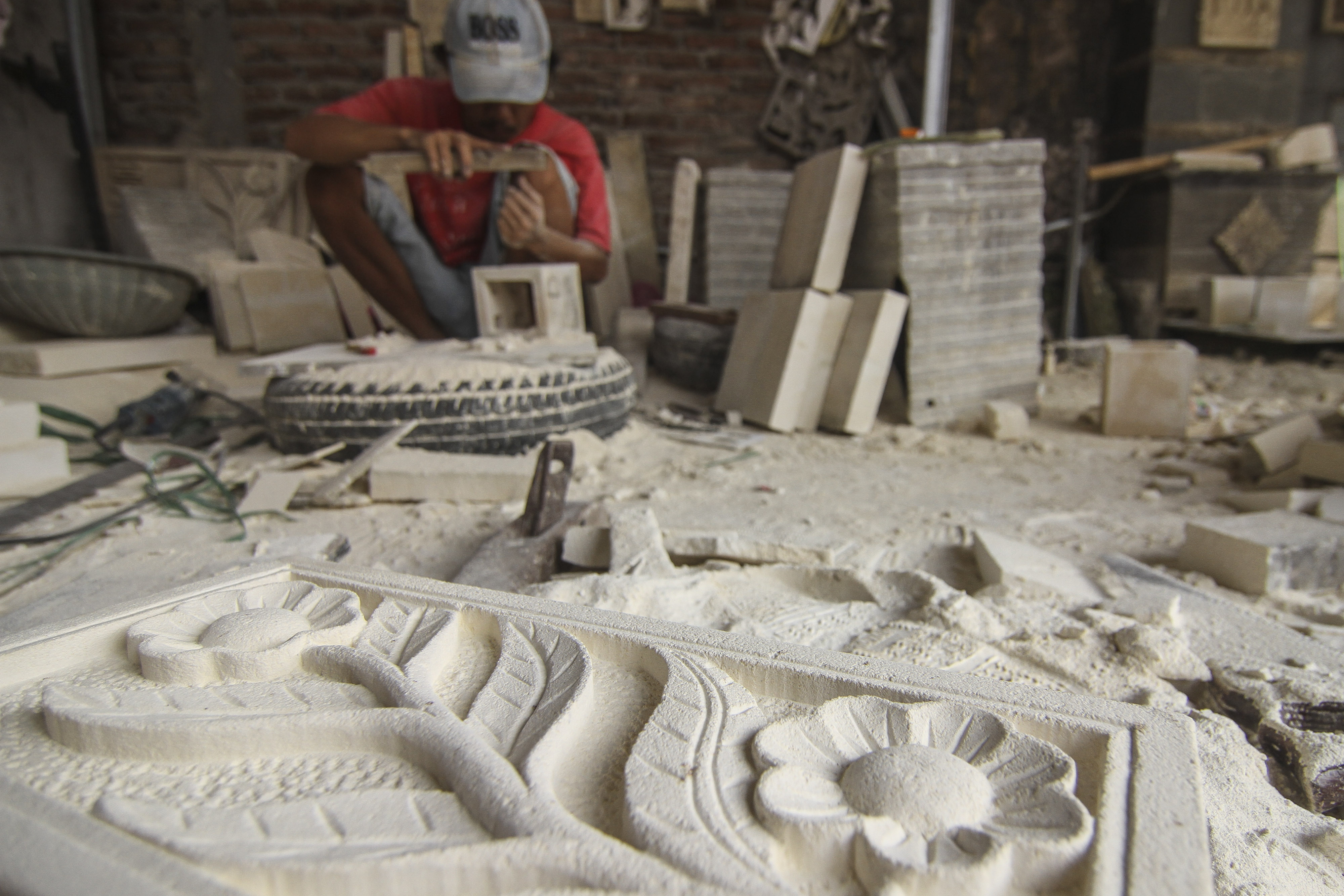 Perajin membuat kerajinan ukir batu paras di Cibubur, Jakarta