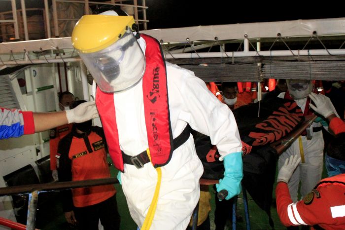 Petugas yang mengenakan APD lengkap membawa jenazah korban kapal tenggelam di Pelabuhan Tenau Kupang, NTT, Minggu (5/7/2020)