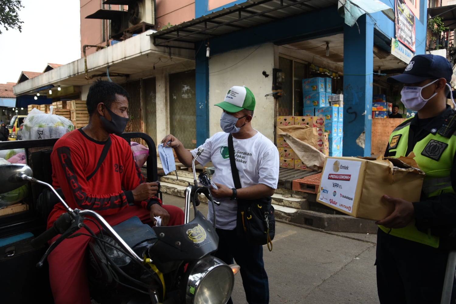 Perwakilan pedagang pasar menggunakan masker pemberian dari Yayasan GPM di Pasar Tanah Tinggi, Kota Tangerang