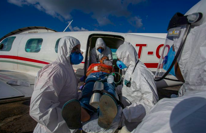 Pasien positif covid-19 Brasil Edinilson Silva, 47, dikeluarkan dari pesawat dengan unit ICU, saat datang ke kota Santarem, Brasil. 