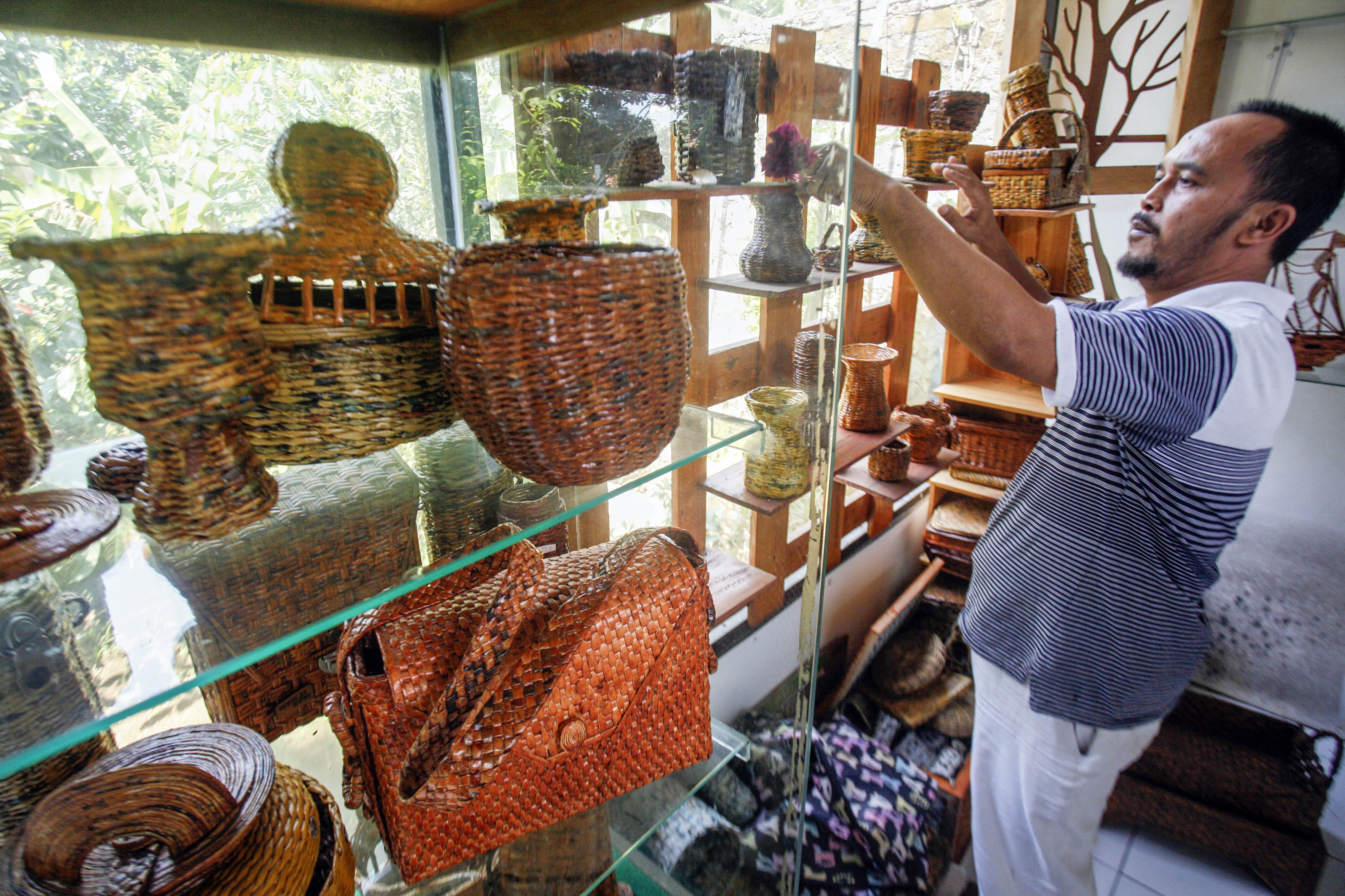 Perajin menata kerajinan berbahan baku koran bekas yang selesai dibuat di sentra kerajinan Craft 11 kopi.