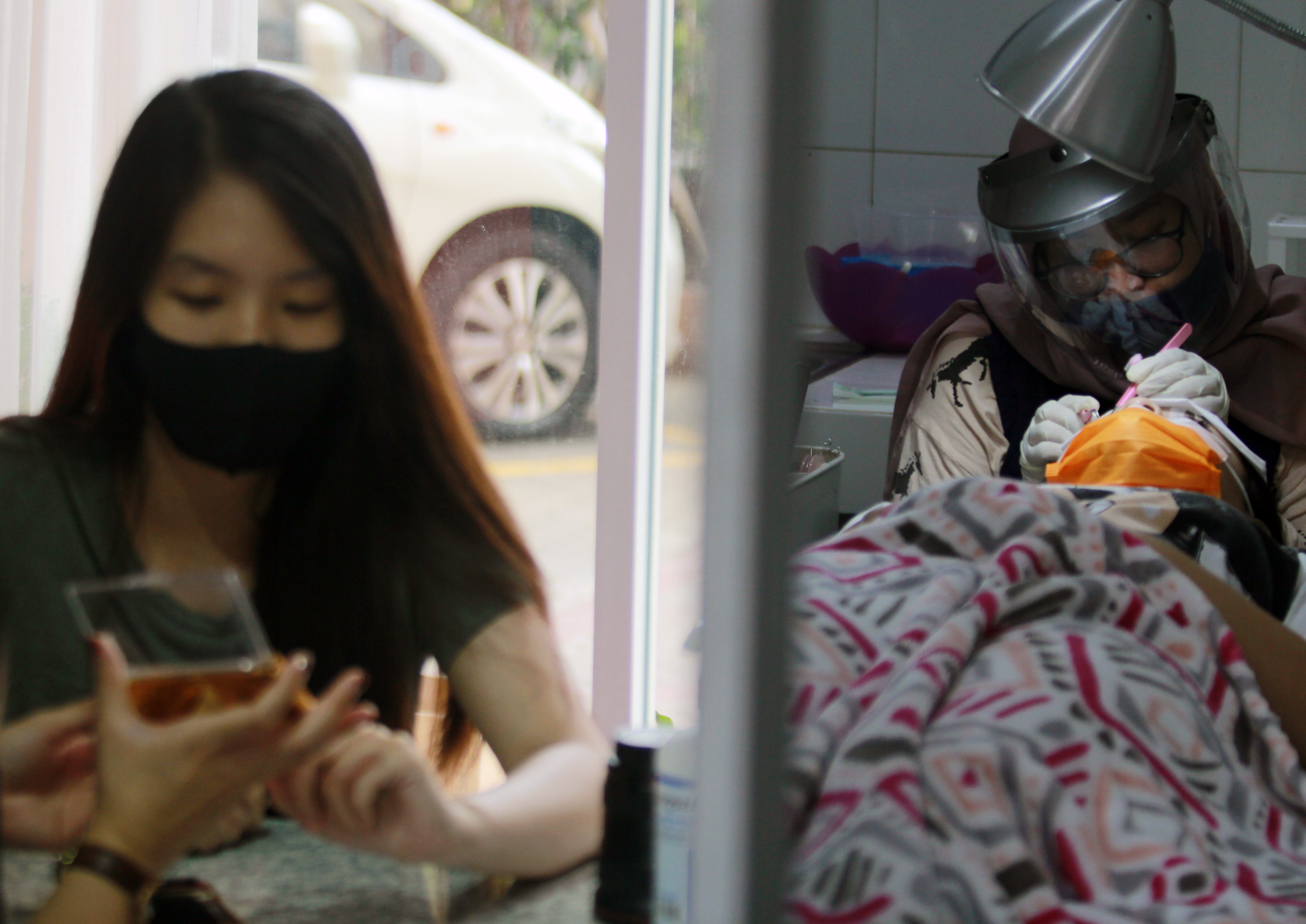 Seorang ahli kecantikan dengan protokol kesehatan yang ketat tengah melakukan sambung bulu mata di The Lash Room Palm Residence Tangerang.