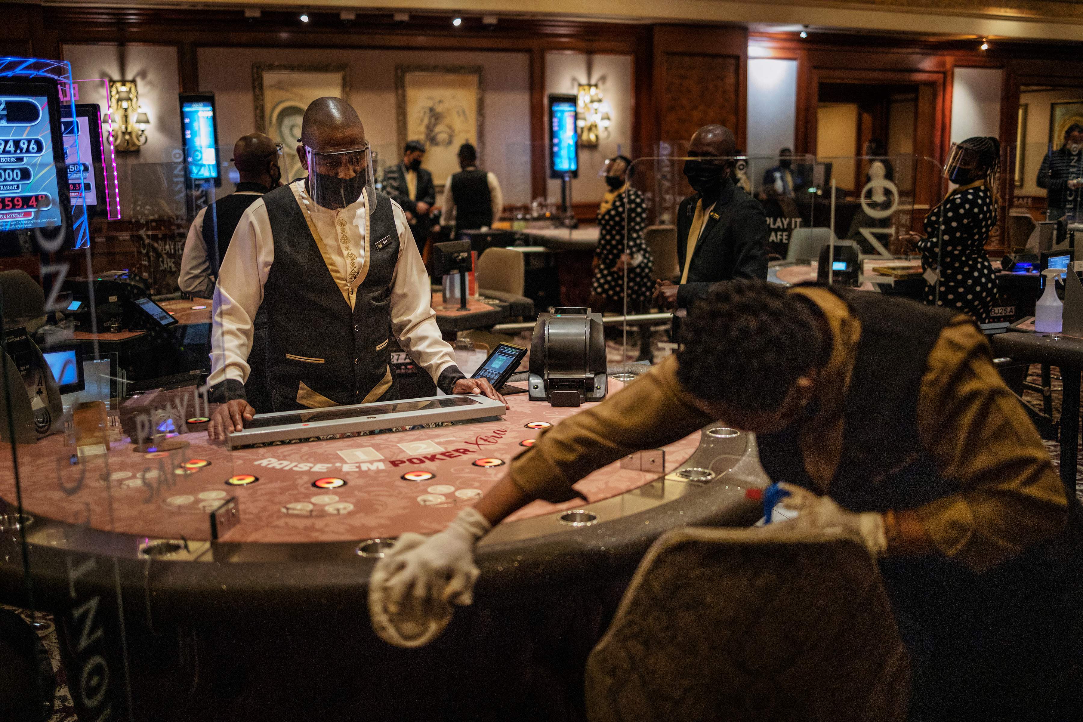 Petugas membersihkan meja poker sebagai bagian protokol kesehatan di kompleks Montecasino, Johannesburg, Afrika Selatan, Jumat (3/7/2020)