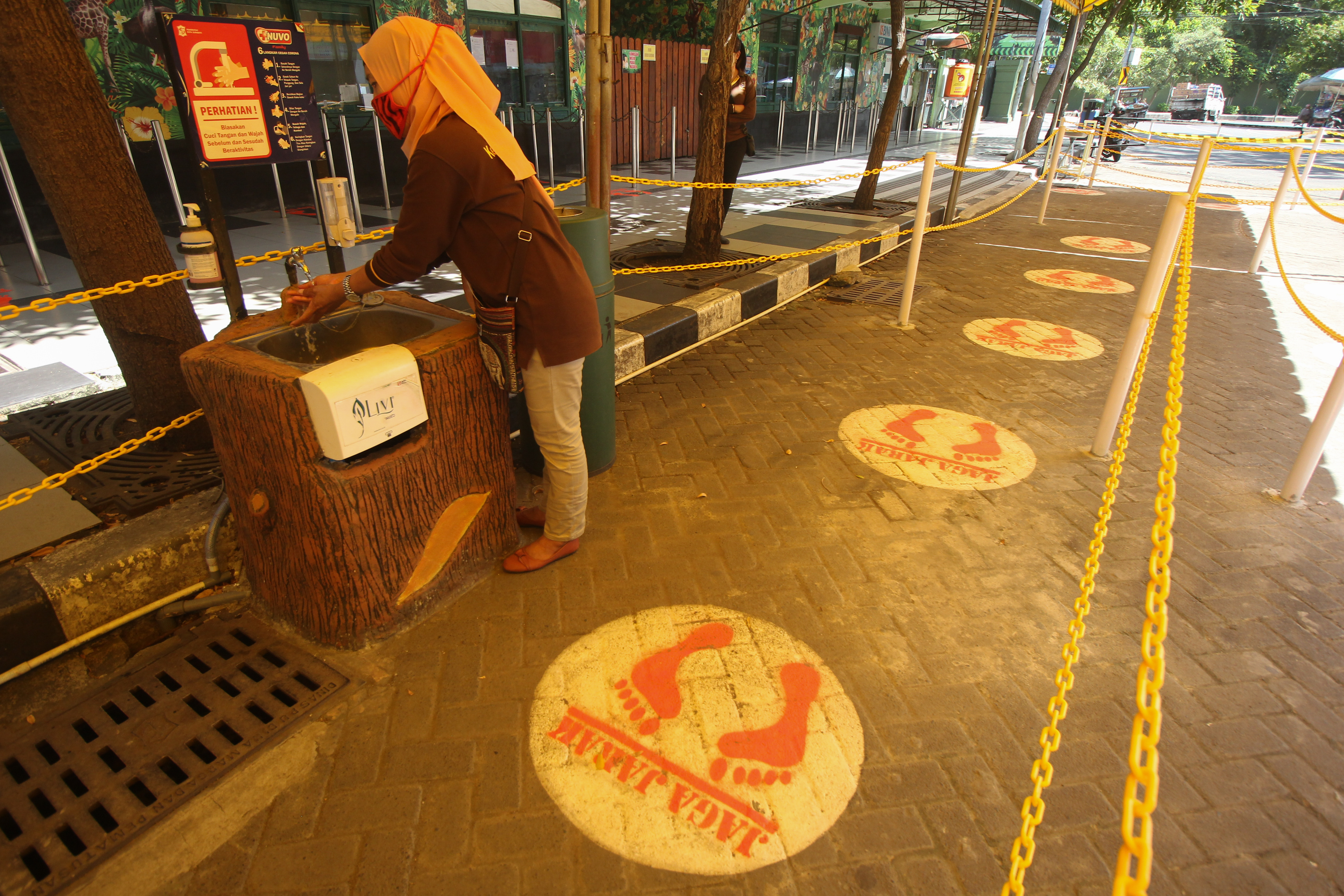 Pekerja mencuci tangan di depan loket Kebun Binatang Surabaya (KBS), Surabaya, Jawa Timur, kemarin.