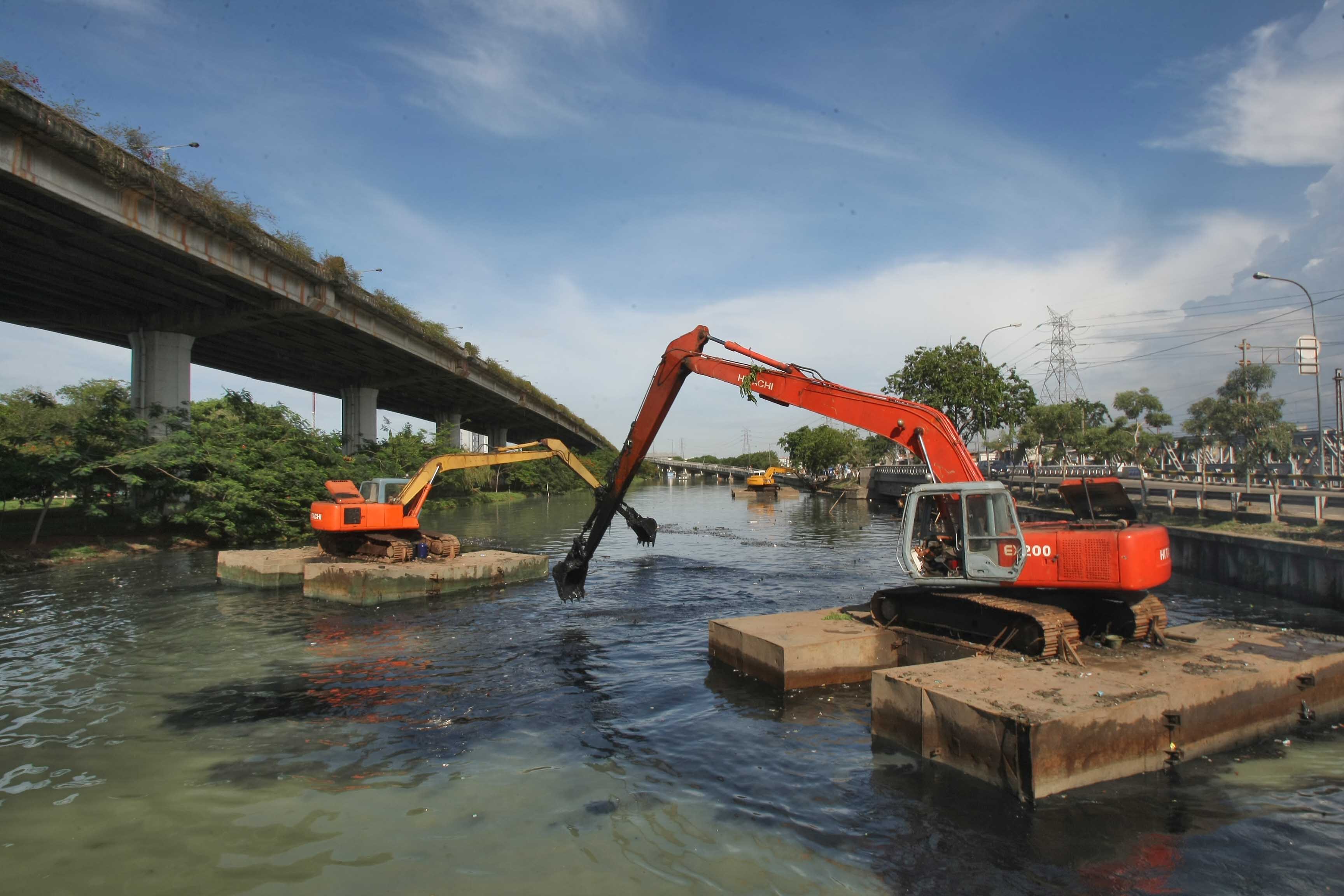 Tiga buah eskavator mengeruk lumpur kali Ancol, Jalan RE Martadinata, Jakarta Utara.