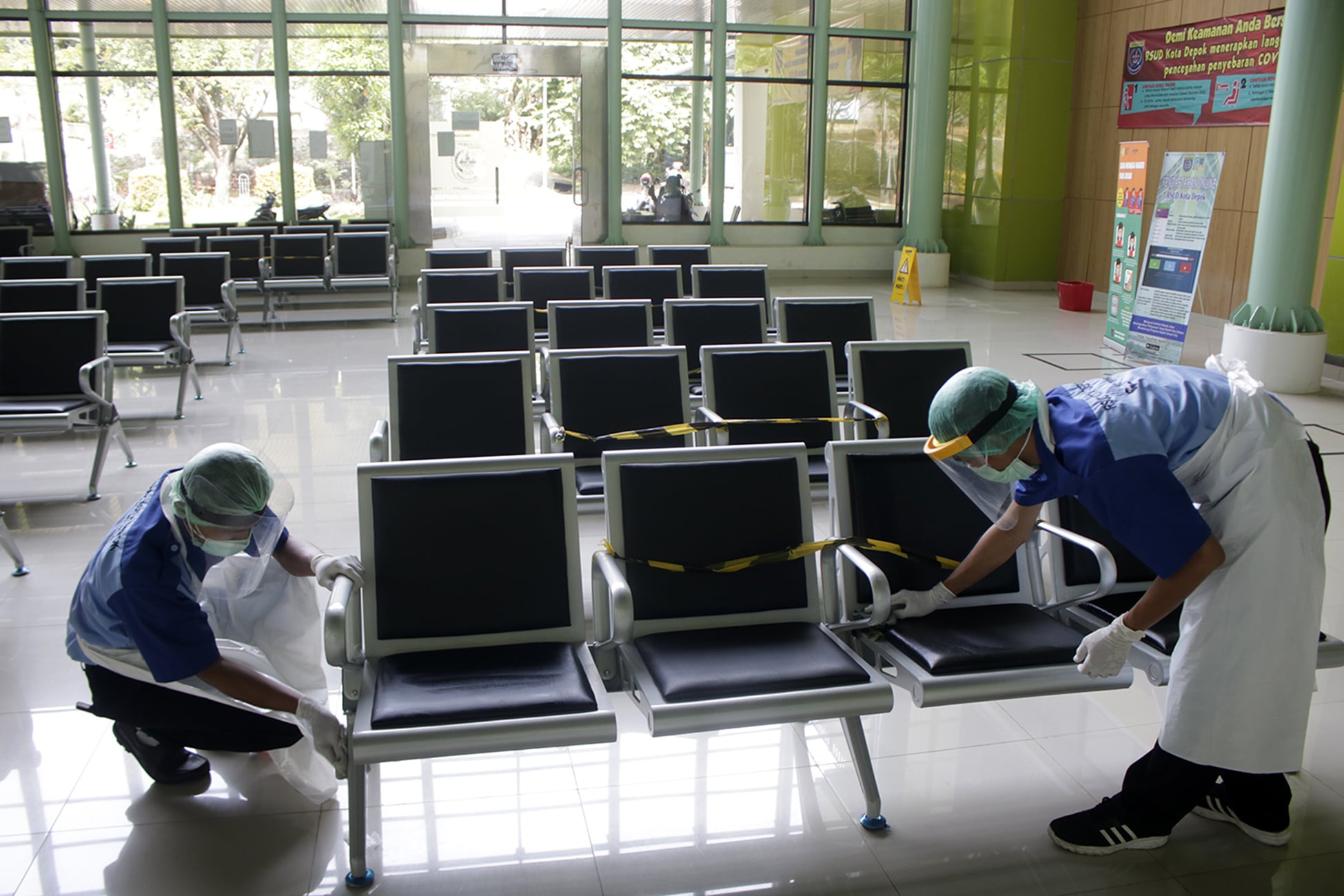 Petugas membersihkan dan mensterilisasi bangku ruang tunggu pasien di Poliklinik RSUD Kota Depok, Sawangan, Depok, Jawa Barat.
