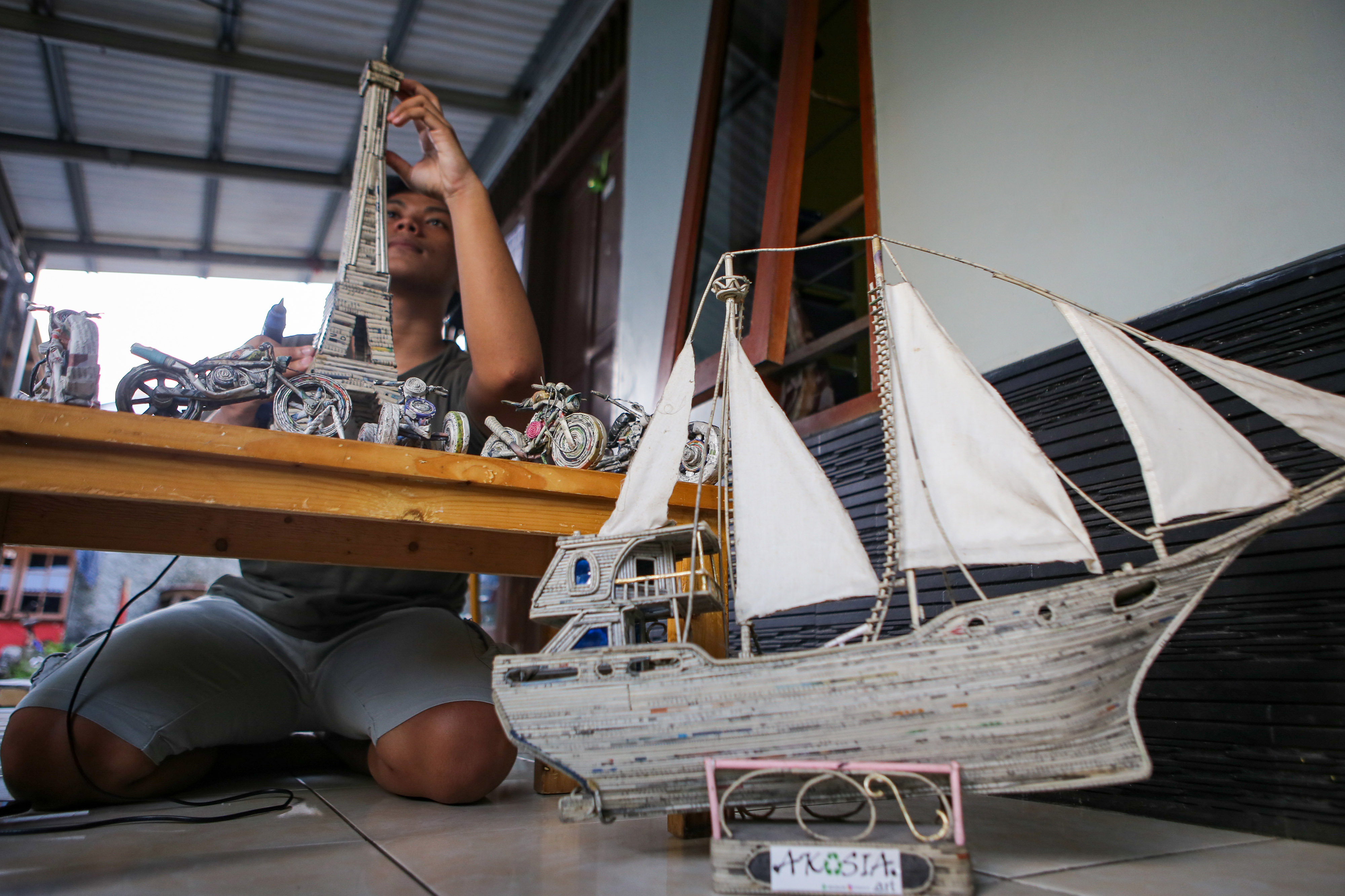 Seorang perajin menyelesaikan proses pembuatan kerajinan dari limbah koran bekas di Pamulang, Tangerang Selatan, Banten, Selasa (30/6).