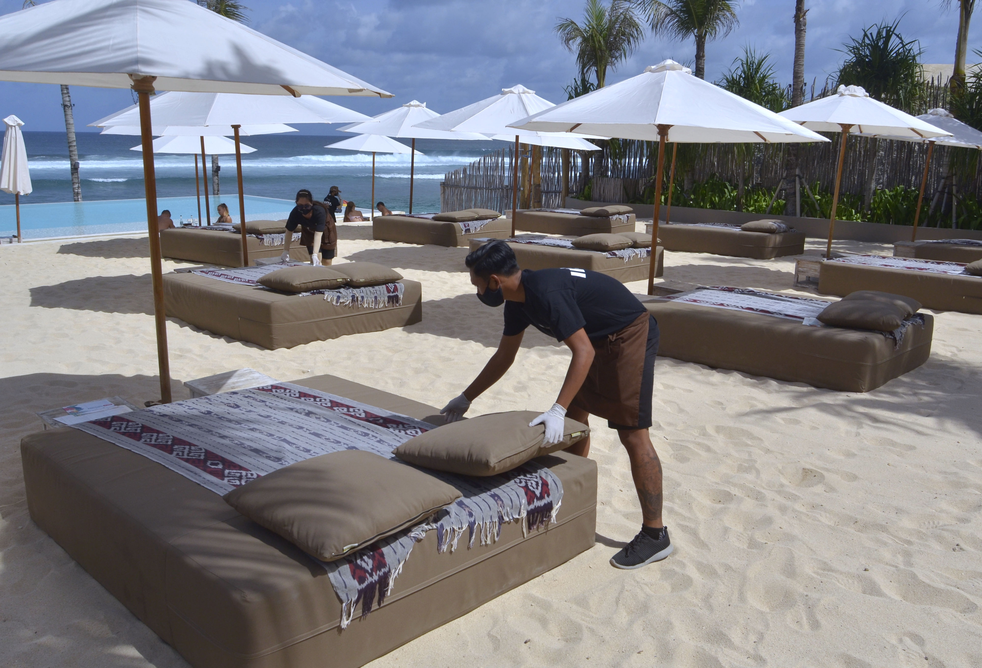 Petugas mengatur jarak kasur pantai di salah satu 'beach club' yang terletak di kawasan Pantai Melasti, Badung, Bali, Rabu (24/6/2020)