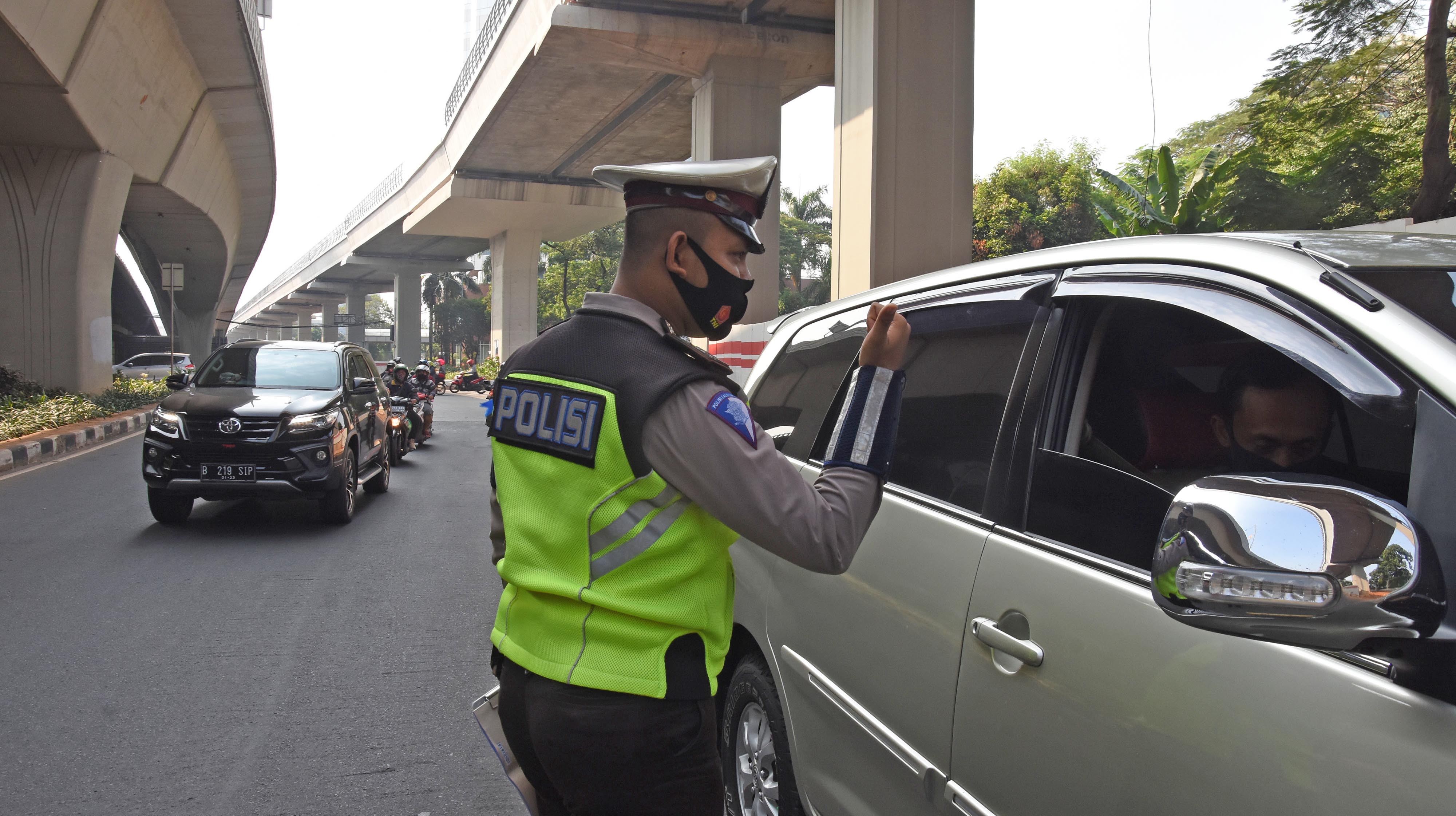 Polantas memberikan sosialisasi kepada pengendara yang melanggar saat hari pertama pemberlakuan kembali kebijakan ganjil-genap