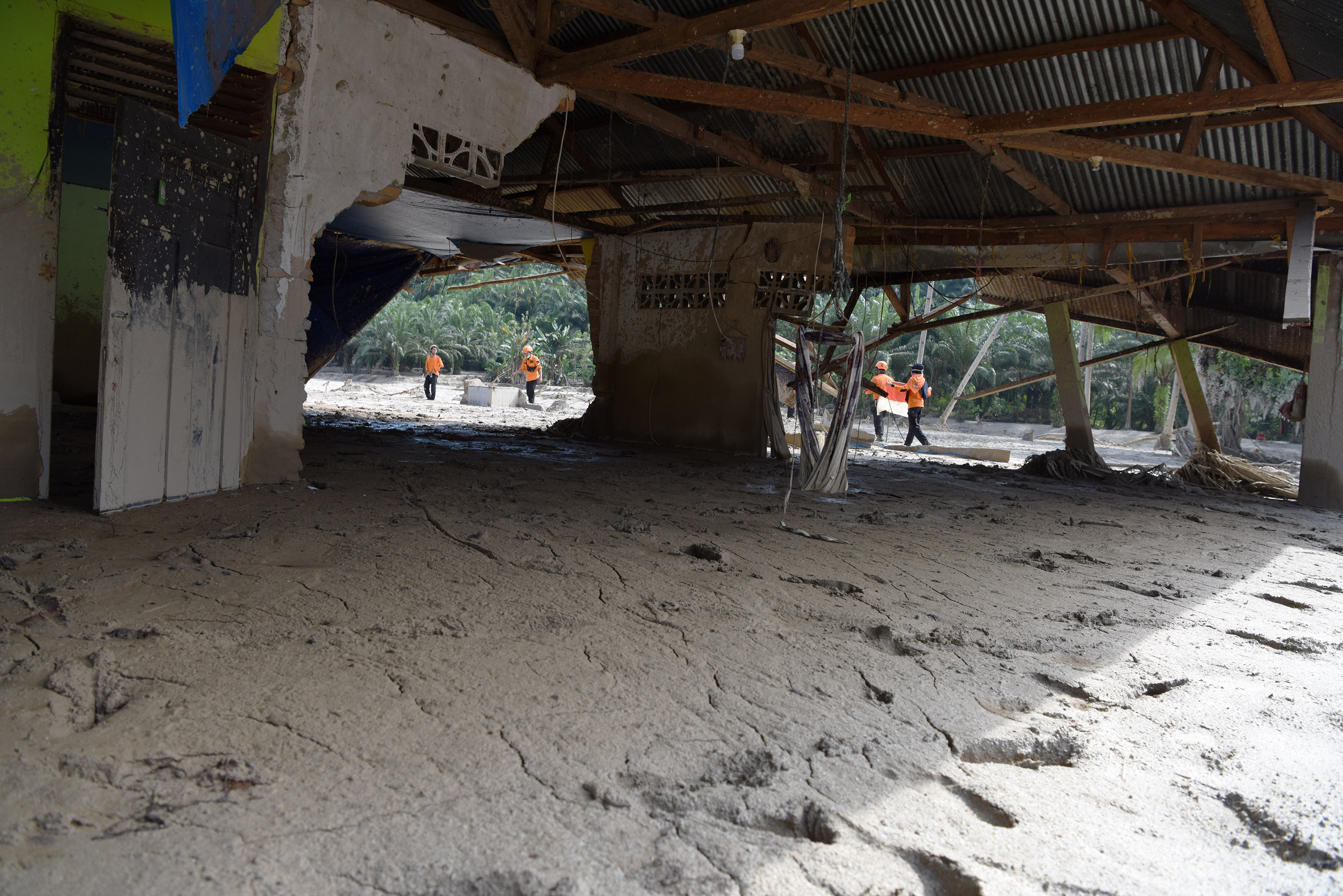 Tim SAR melintas di dekat rumah yang rusak akibat diterjang banjir bandang di Desa Petambua Masamba, kabupaten Luwu Utara, Sulawesi Selatan.