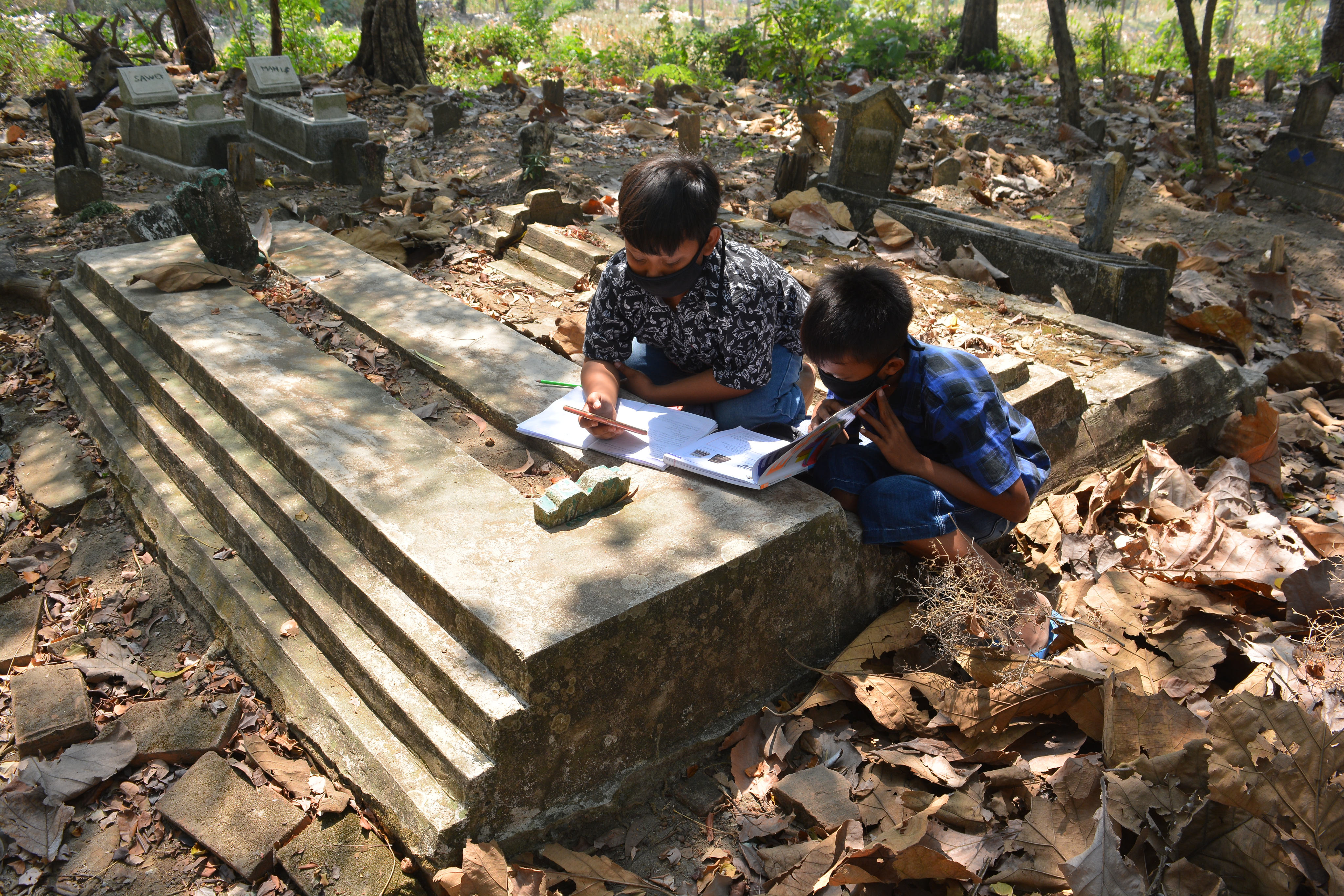  Sejumlah siswa kelas 6 SDN Sumberaji 2 mengerjakan tugas pelajaran sekolah secara daring di kawasan makam Dusun Ngapus, Jombang, Jatim.