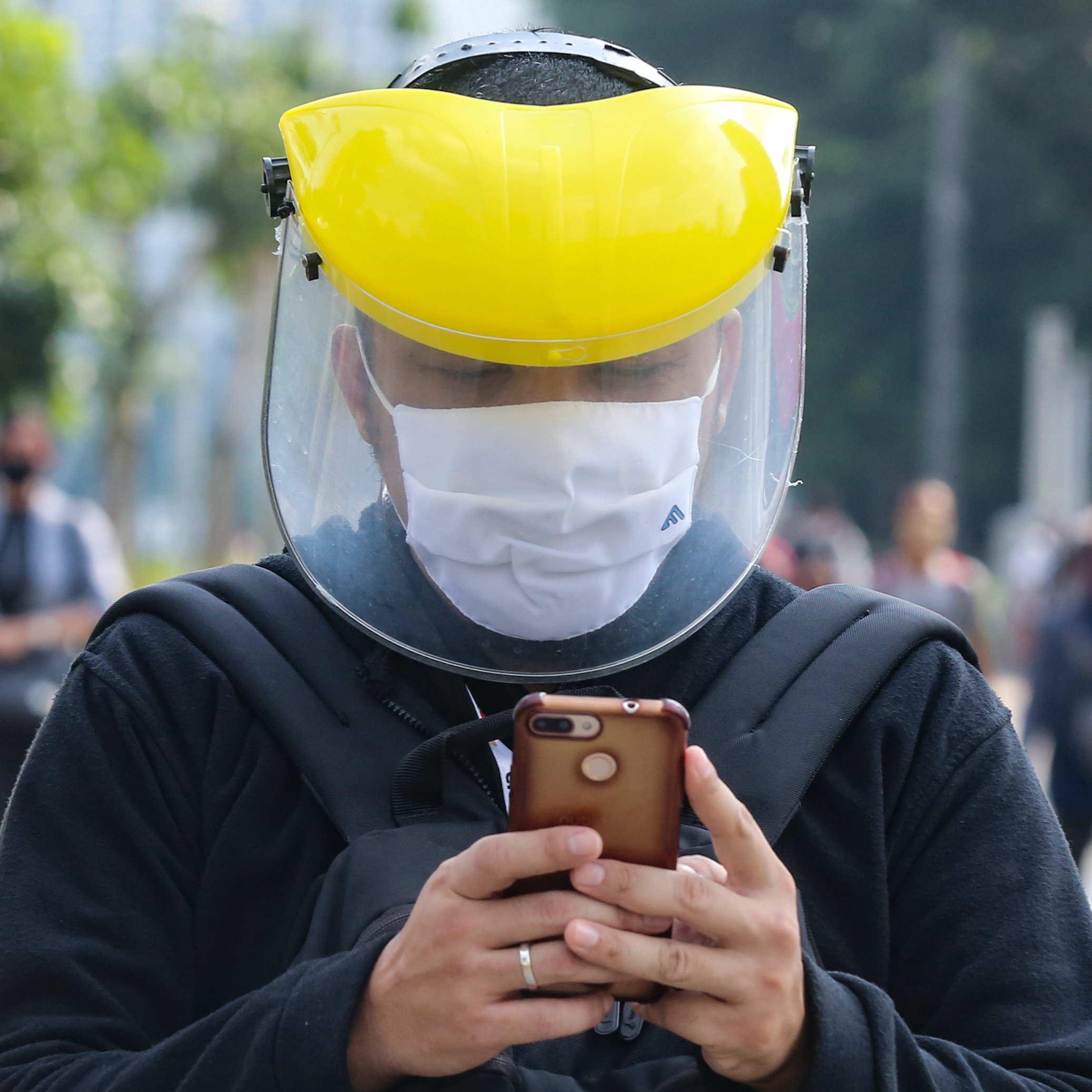 Pekerja menggunakan masker dan pelindung wajah menuju kantornya saat melewati trotoar di kawasan Sudirman, Jakarta, Senin (8/6).