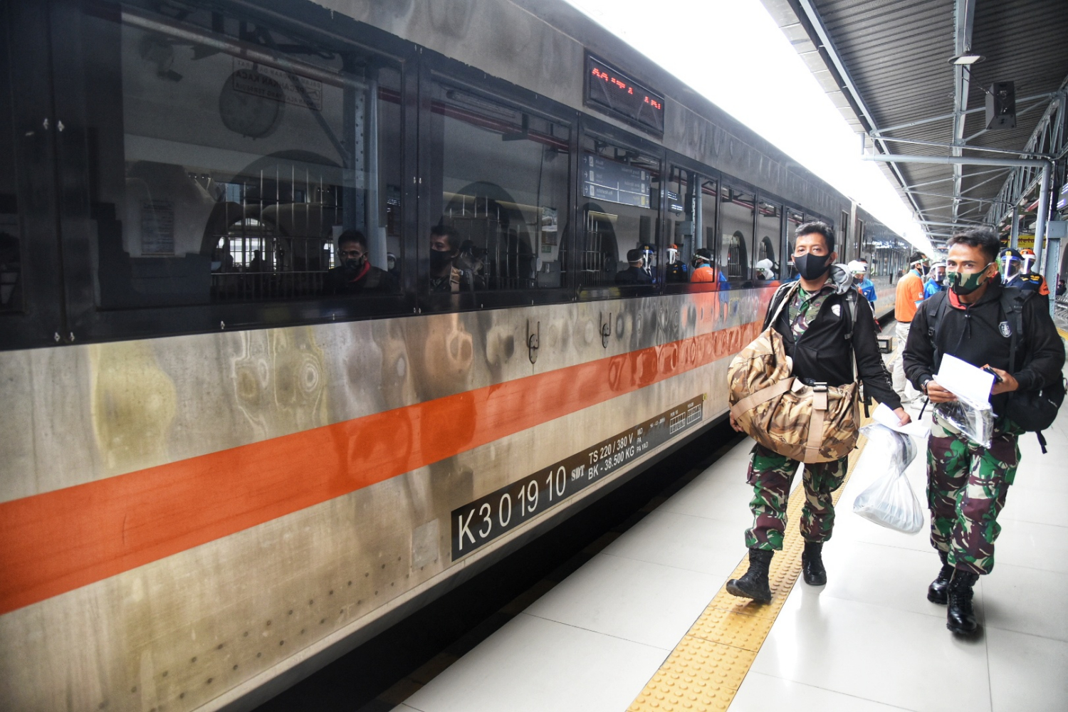 Penumpang mengenakan masker saat bepergian dengan kereta api jarak jauh