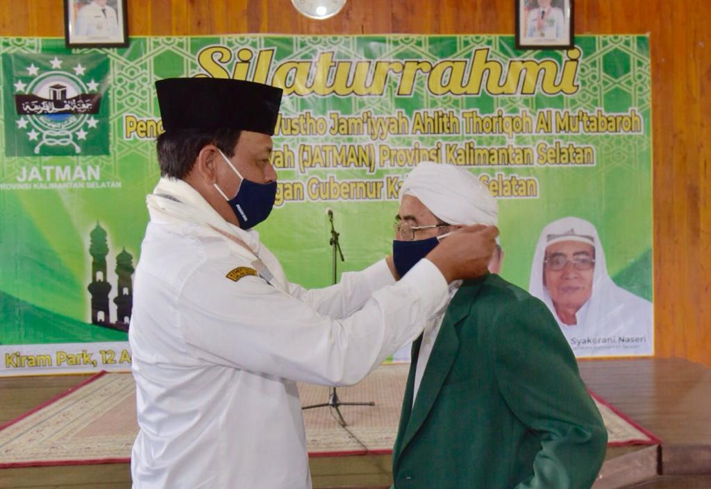  Gubernur Kalsel, Sahbirin Noor memasangkan masker ke ulama. Ia mengajak para ulama dan pemimpin agama lainnya untuk memerangi covid-19.