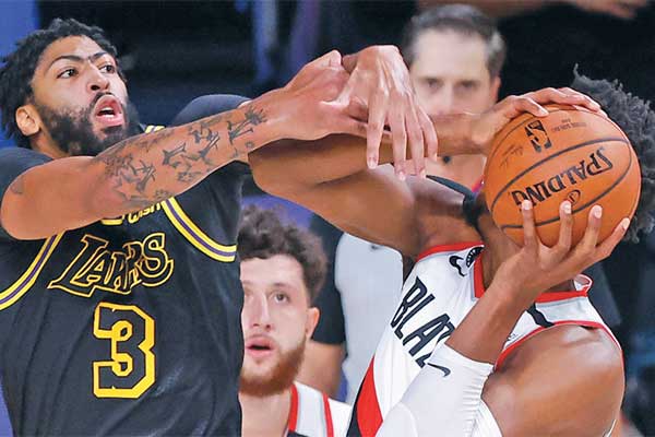 Pemain Los Angeles Lakers Anthony Davis (kiri) menutup pergerakan pemain Portland Trail Blazers Hassan Whiteside 