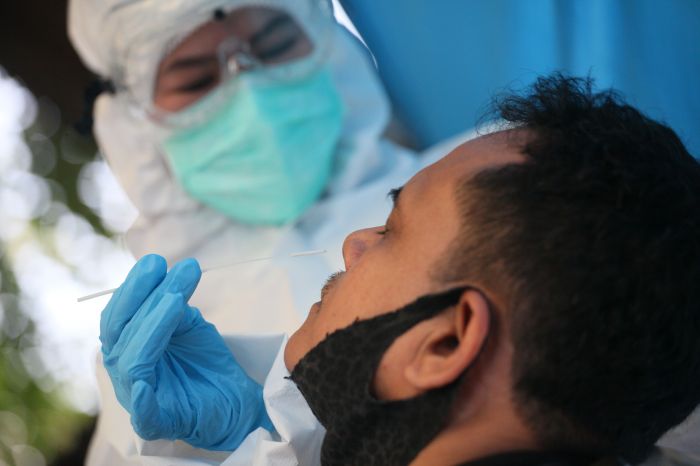 Tenaga medis melakukan swab test pada pedagang di Pasar Patra, Jakarta.