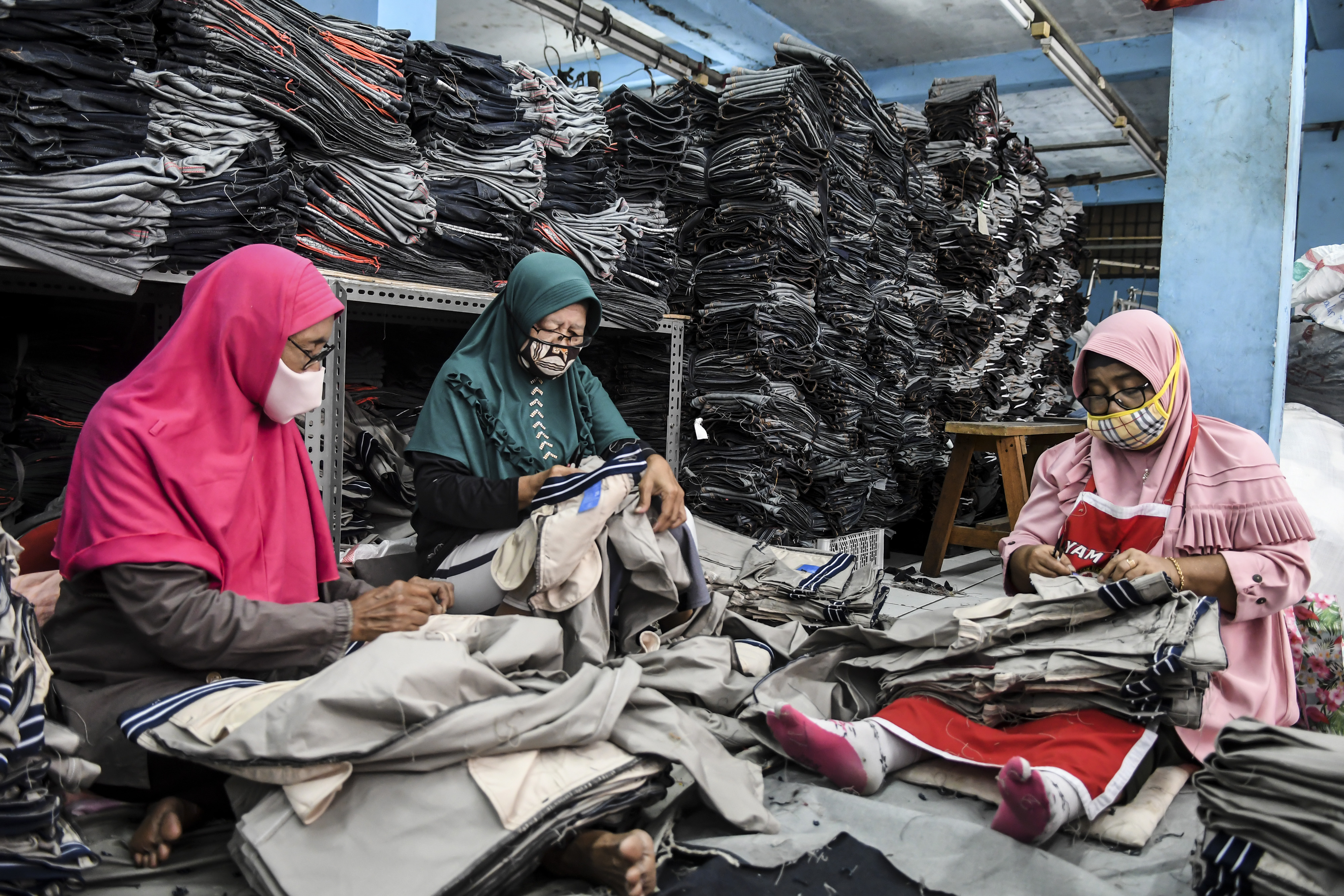 Pekerja usaha kecil menengah (UKM) menyelesaikan pembuatan celana berbahan denim di Pusat Industri Kreatif, Jakarta, Rabu (26/8).