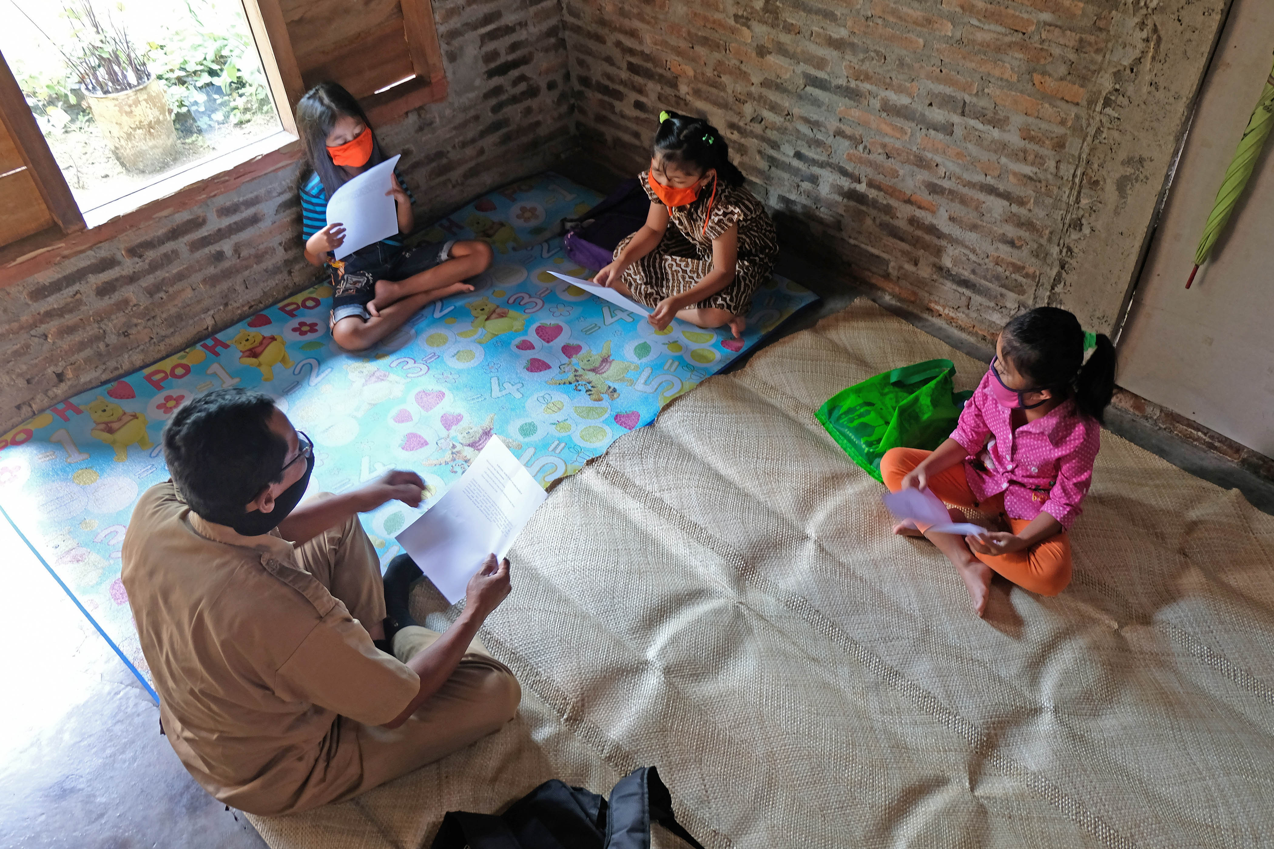 Guru SD Kanisius Kenalan Henricus Suroto (kiri) mengajar di rumah warga di kawasan pegunungan Menoreh, Dusun Plengan, Kulonprogo, DIY. 