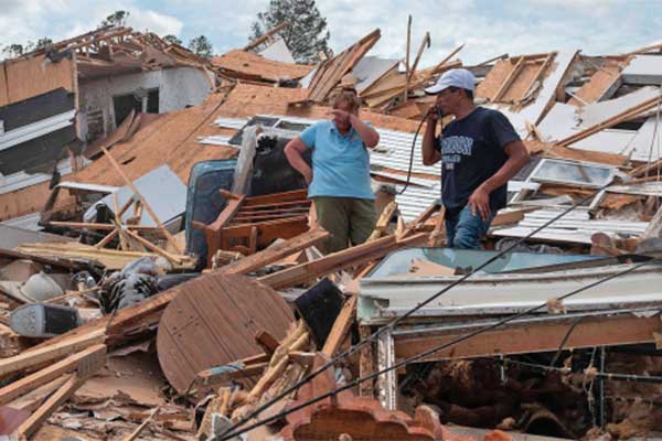 Pasangan suami istri berada di antara reruntuhan rumah mereka yang hancur diterjang badai Laura 