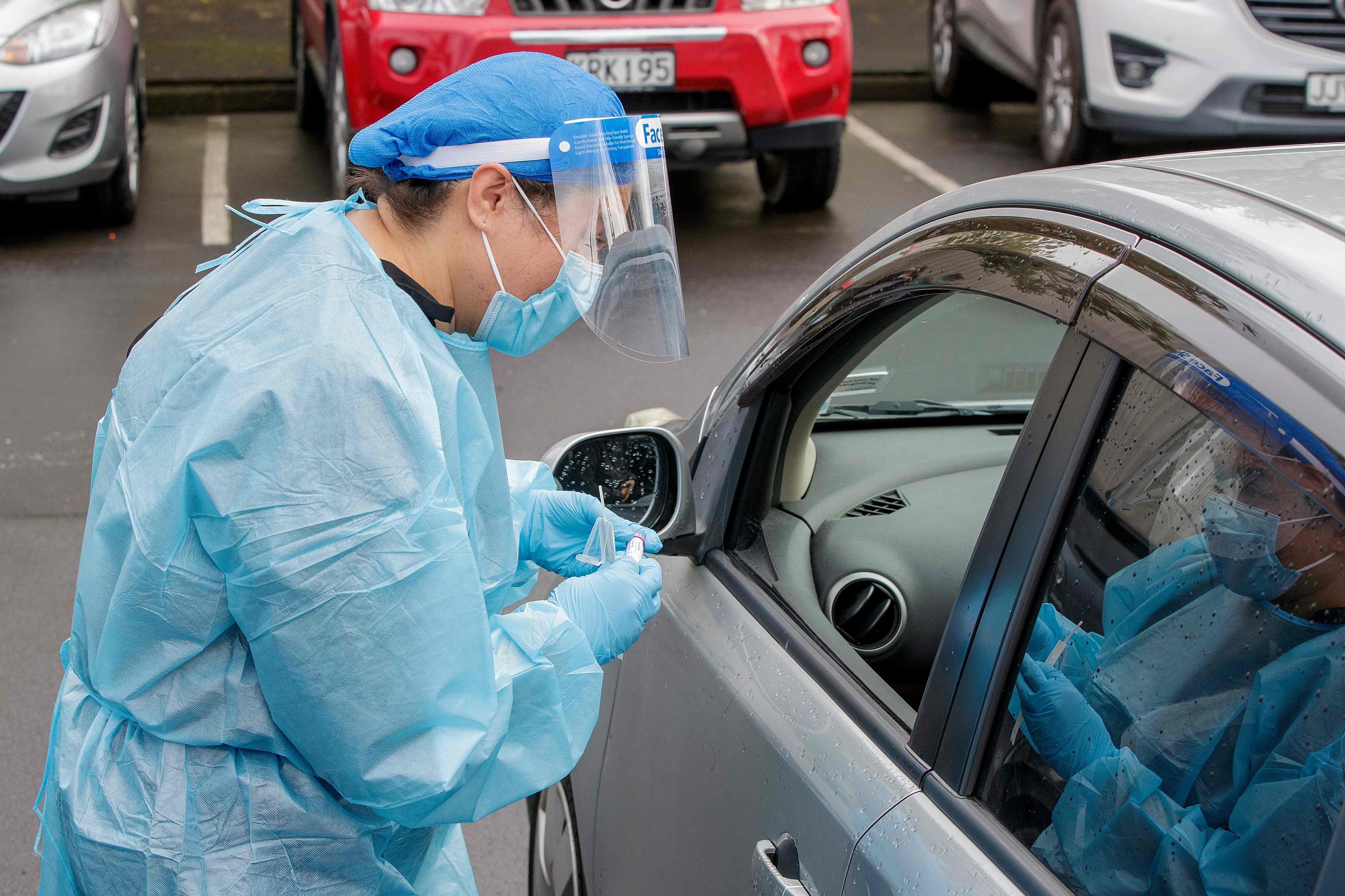 Petugas kesehatan melakukan tes di pusat pengujian virus covid-19 di Northcote di Auckland pada 12 Agustus 2020.