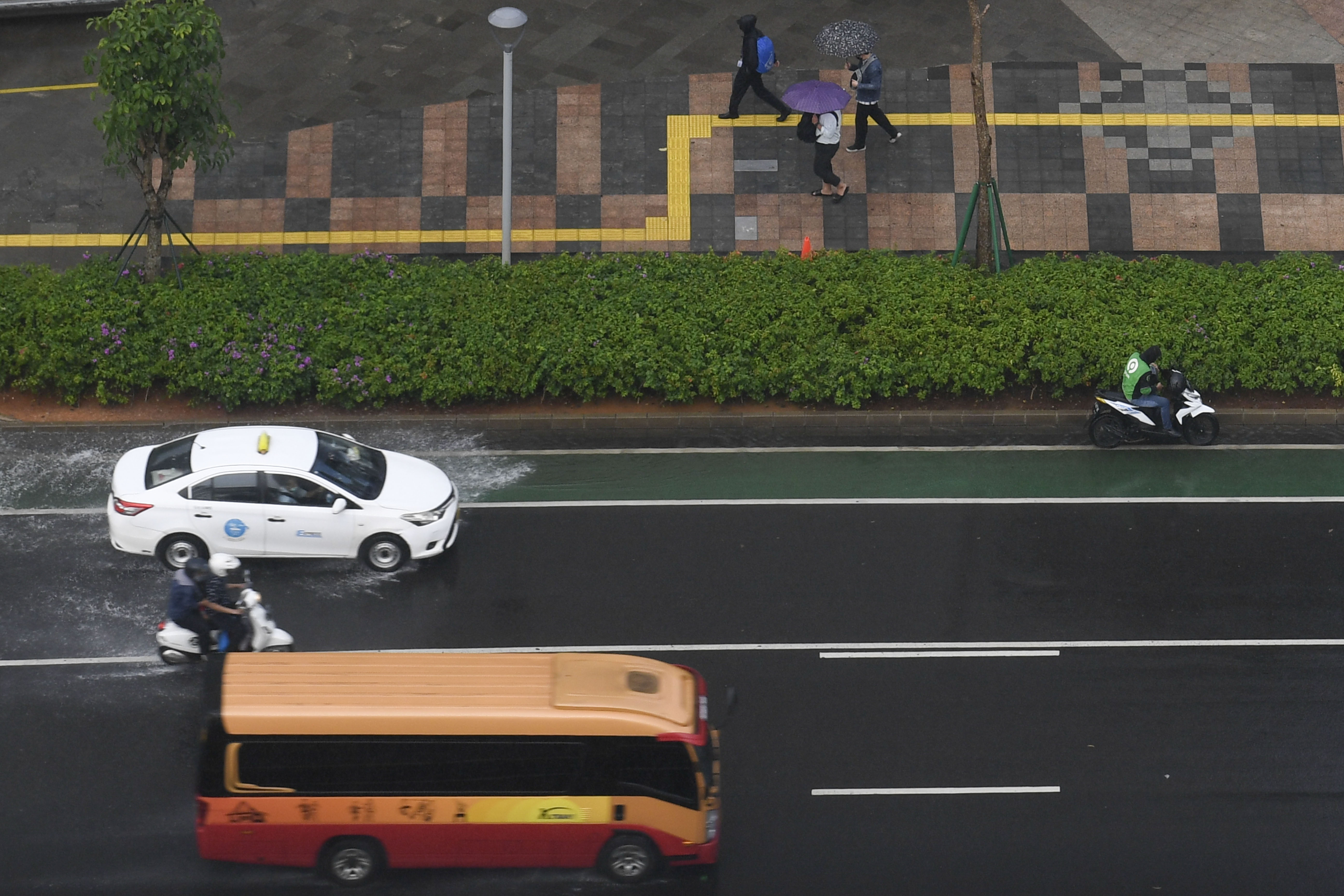 Sejumlah pengguna jalan melintas saat hujan mengguyur di kawasan Jalan Jenderal Sudirman, Jakarta.