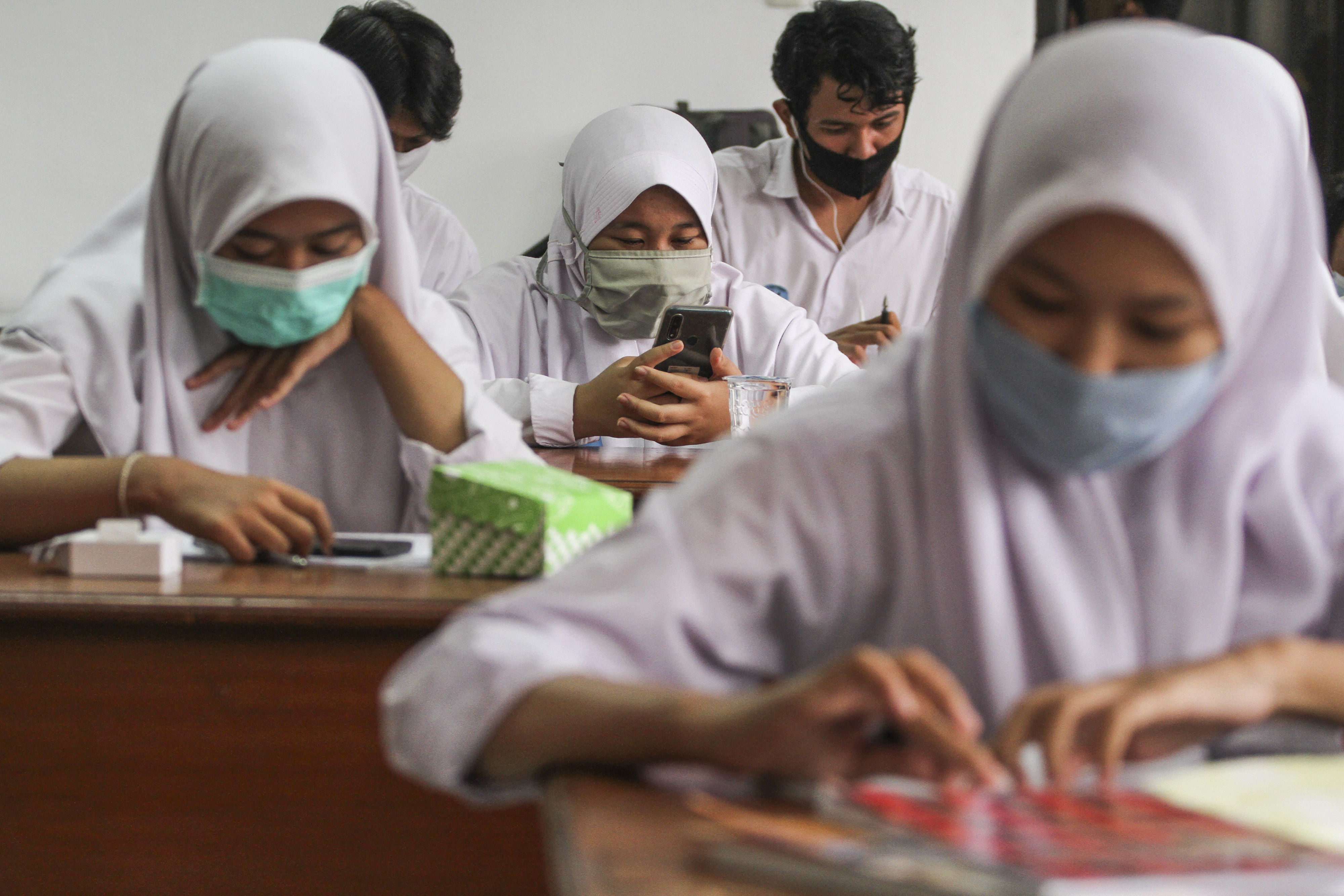 Sejumlah pelajar menggunakan wifi gratis di perpustakaan Kejaksaan Negeri Kota Depok, Jawa Barat, Selasa (18/8).