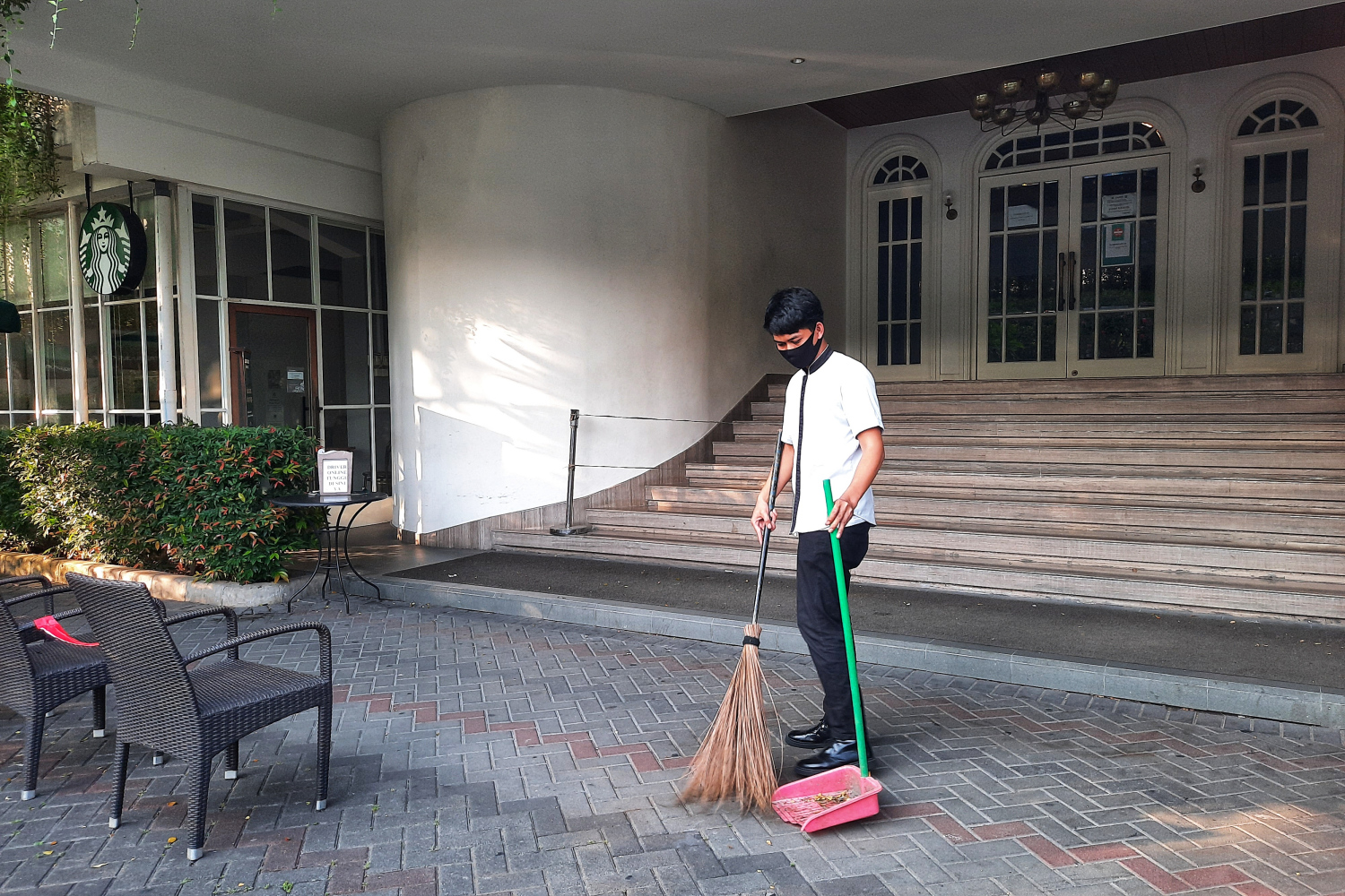 Seorang petugas menyapu halaman depan bioskop The Premiere Metropole XXI Megaria di Jakarta Pusat.